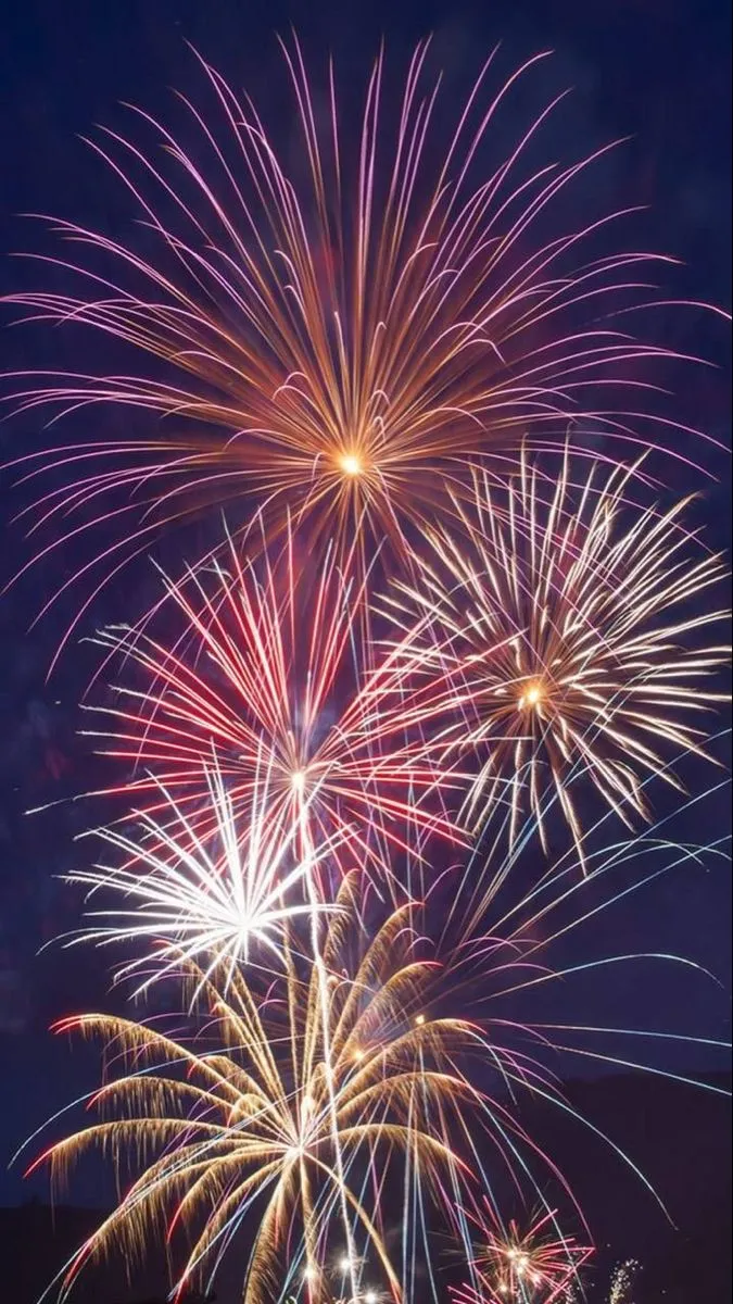 Fireworks display with red and yellow bursts in the sky