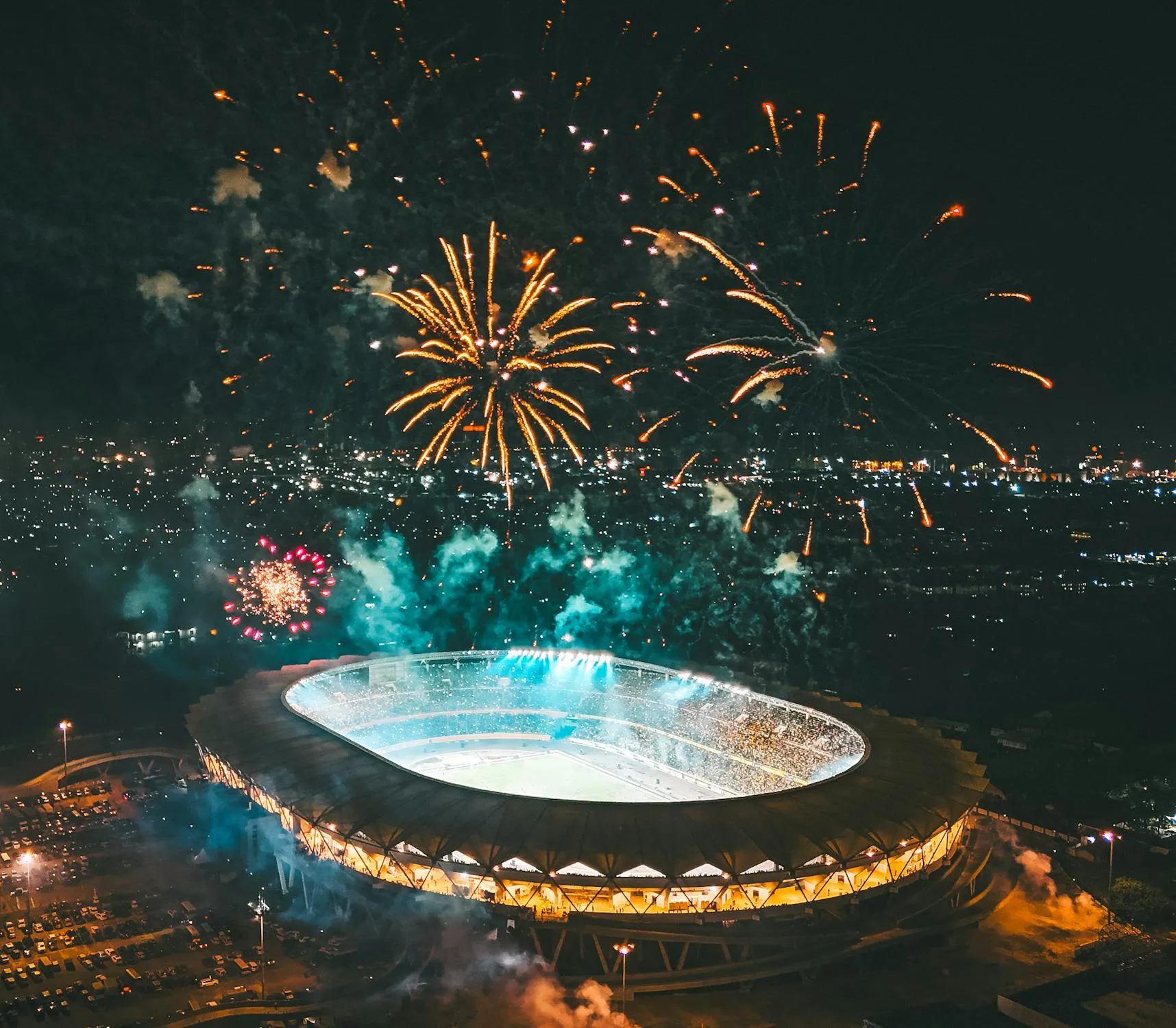 Fireworks exploding above a large stadium at night