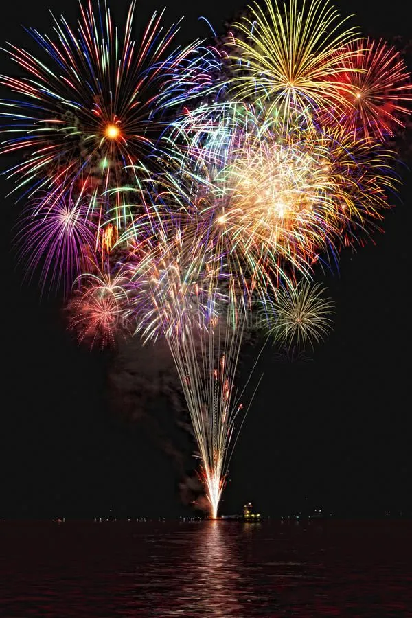 Fireworks exploding beautifully over the water at night