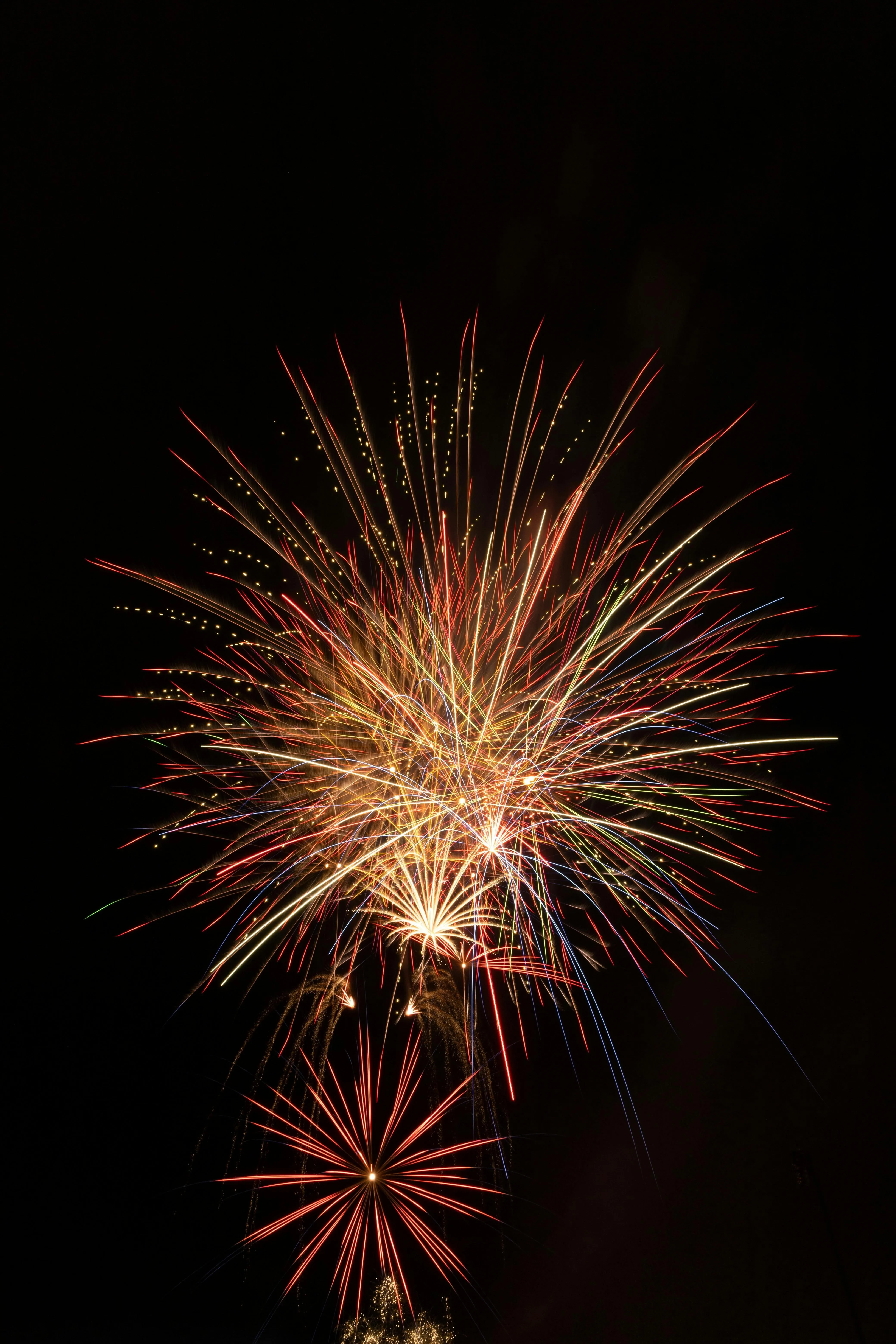 Fireworks Exploding in the Night Sky over Water Wallpaper