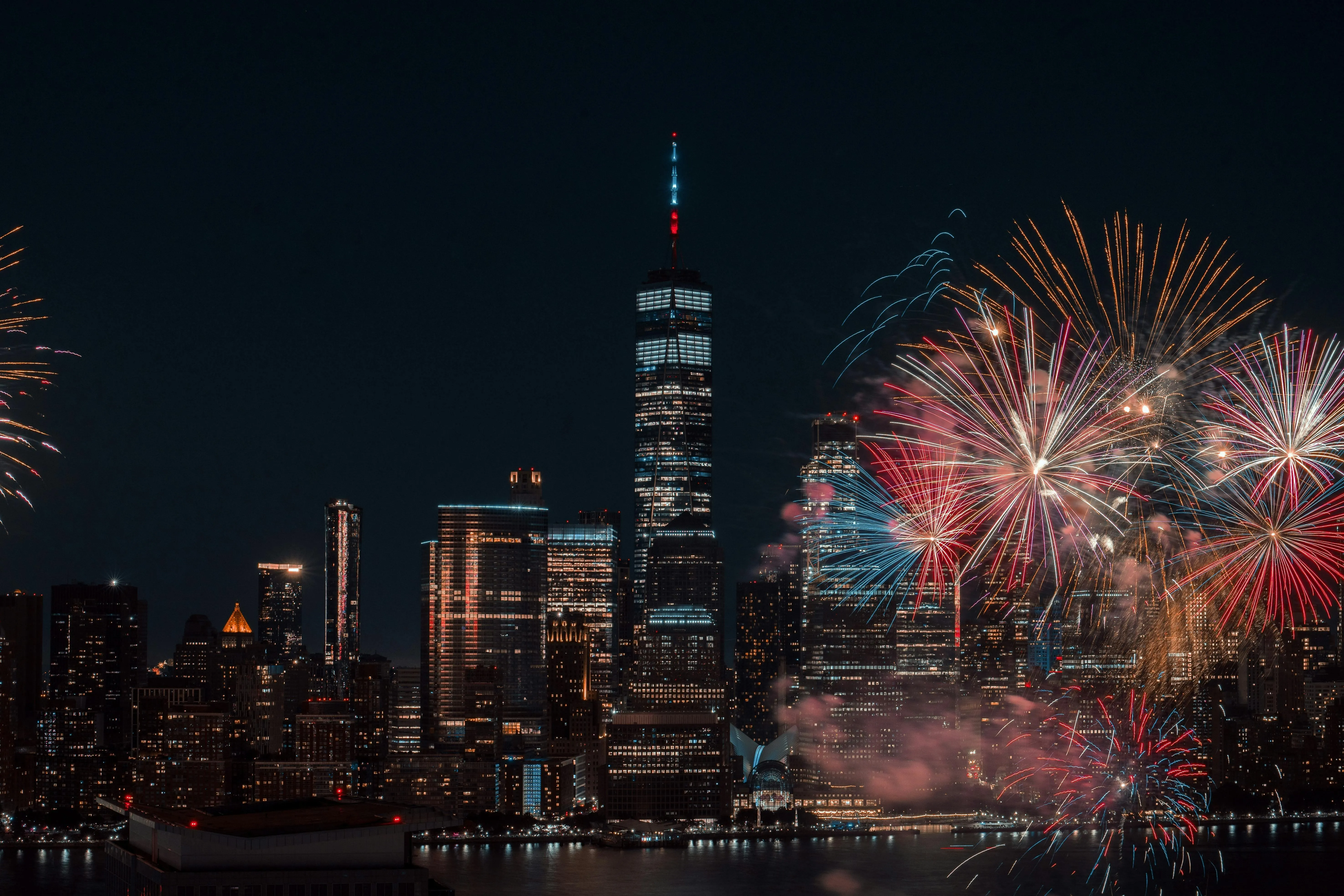 Fireworks light up the sky with city buildings in the backdrop