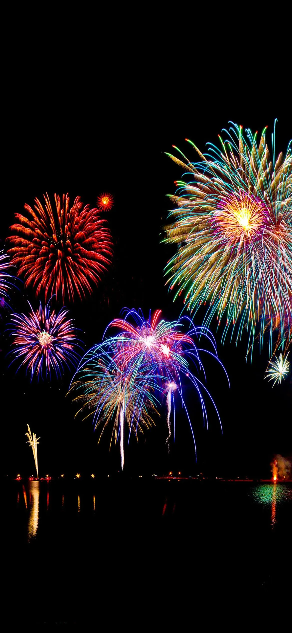 Fireworks Lighting up the Night over A Calm Waterfront