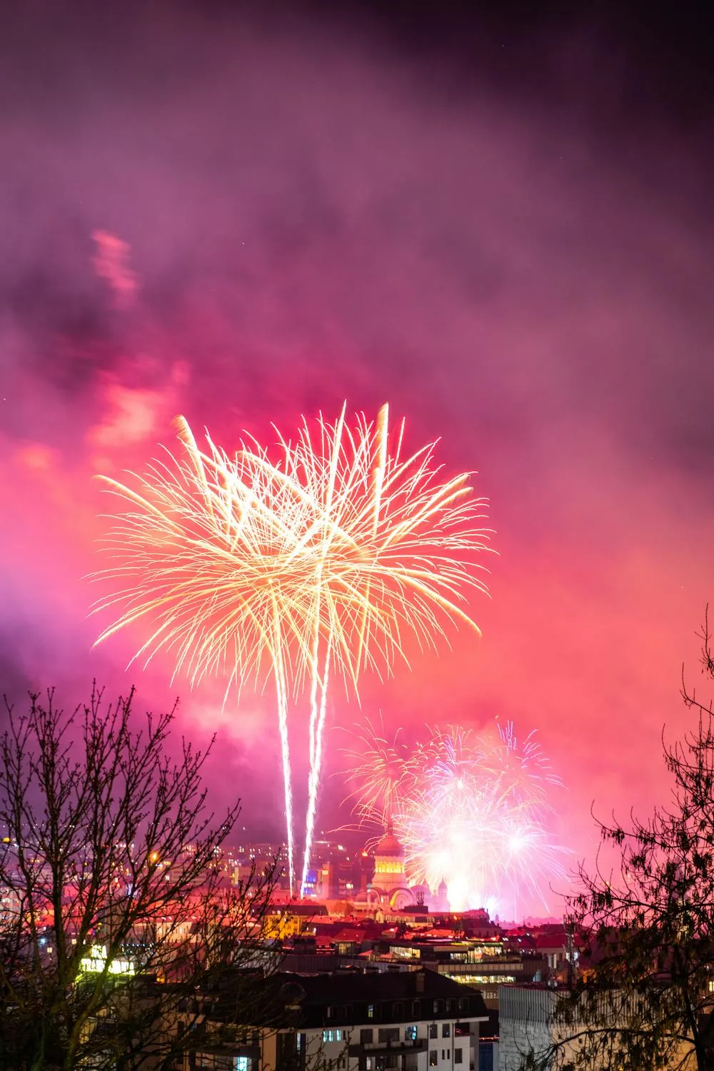 Fireworks over a town creating a glowing colorful scene