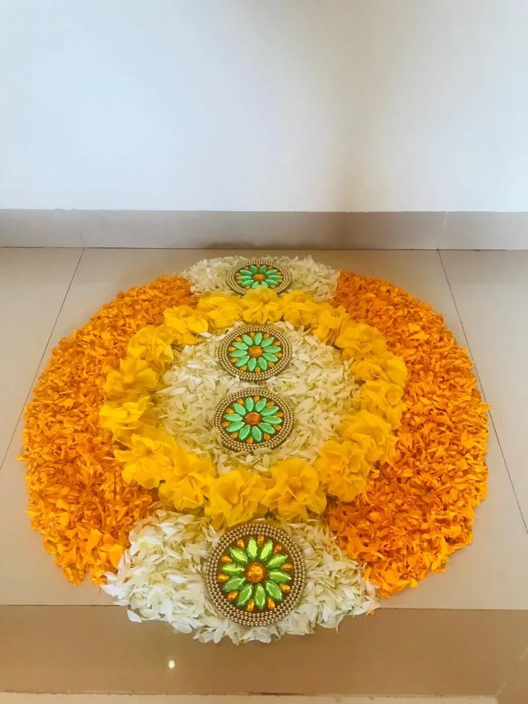 Floral pookolam with orange and white flower petals image