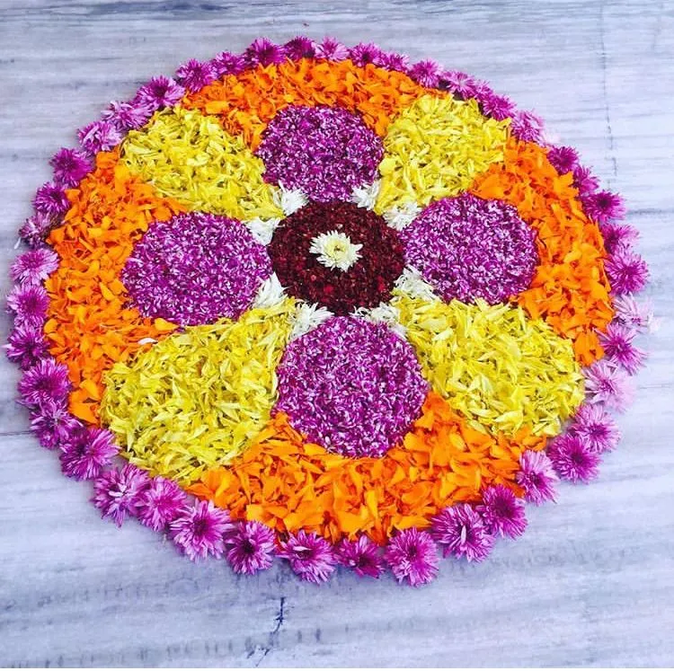 Flower pookolam with vibrant purple yellow and orange petals
