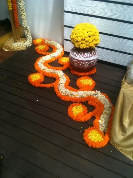 flowing pathway Onam design pookolam with apot Wallpaper