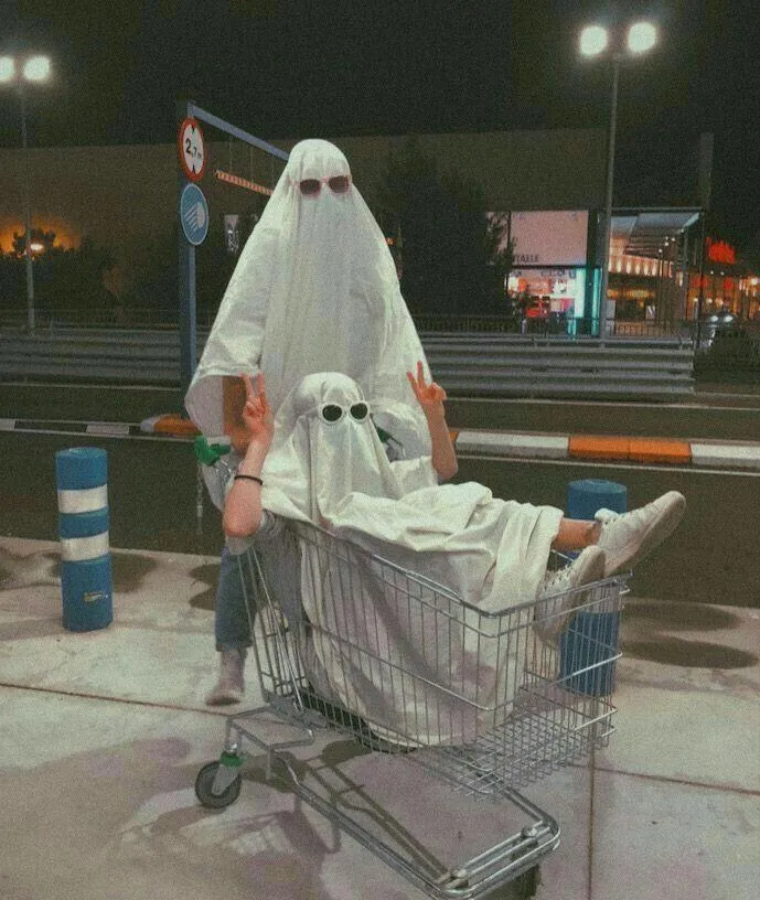 Friends Dressed as Ghost in Shopping Cart at Night Wallpaper