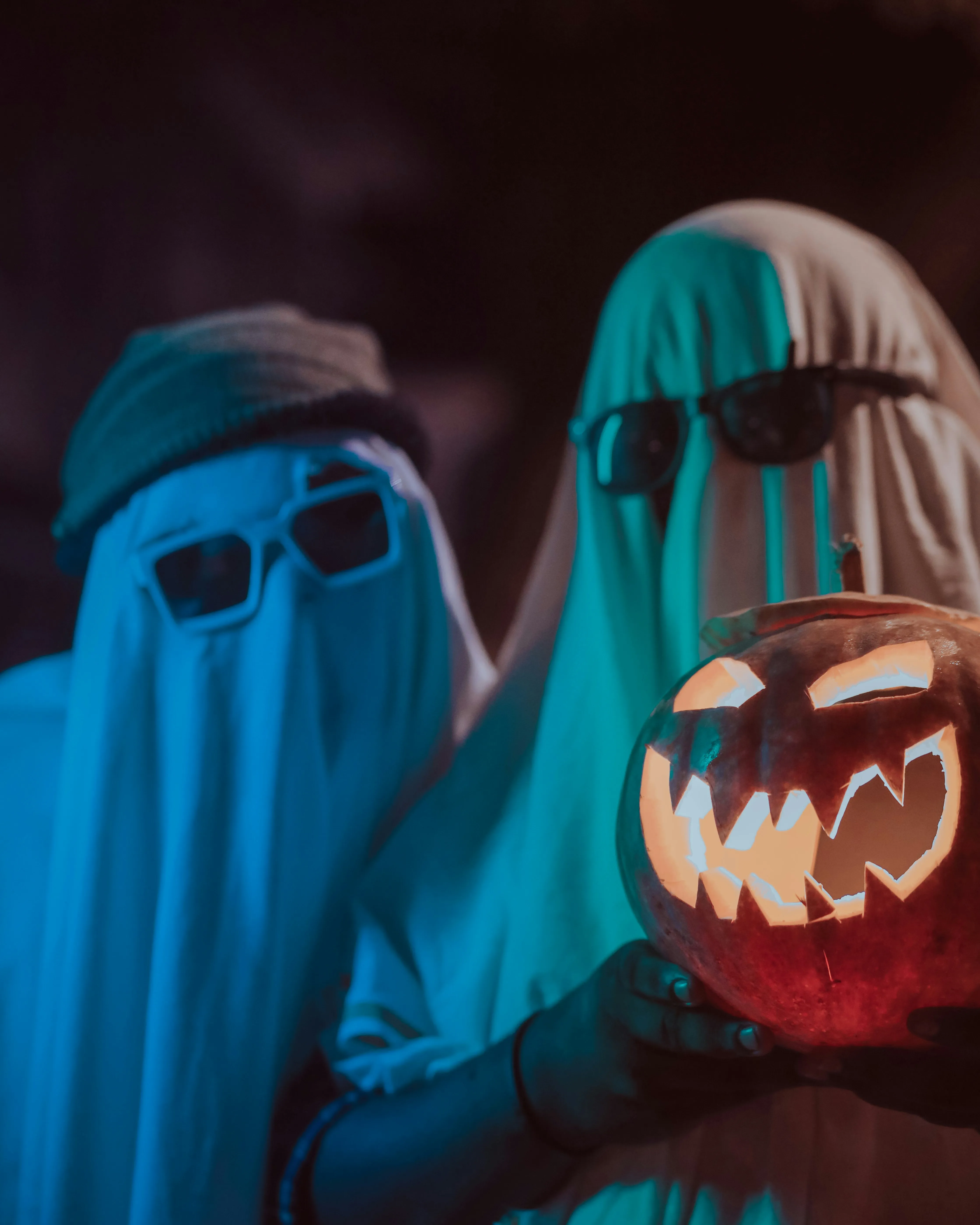 Friends in Ghost Costumes Holding Pumpkin Lanterns image