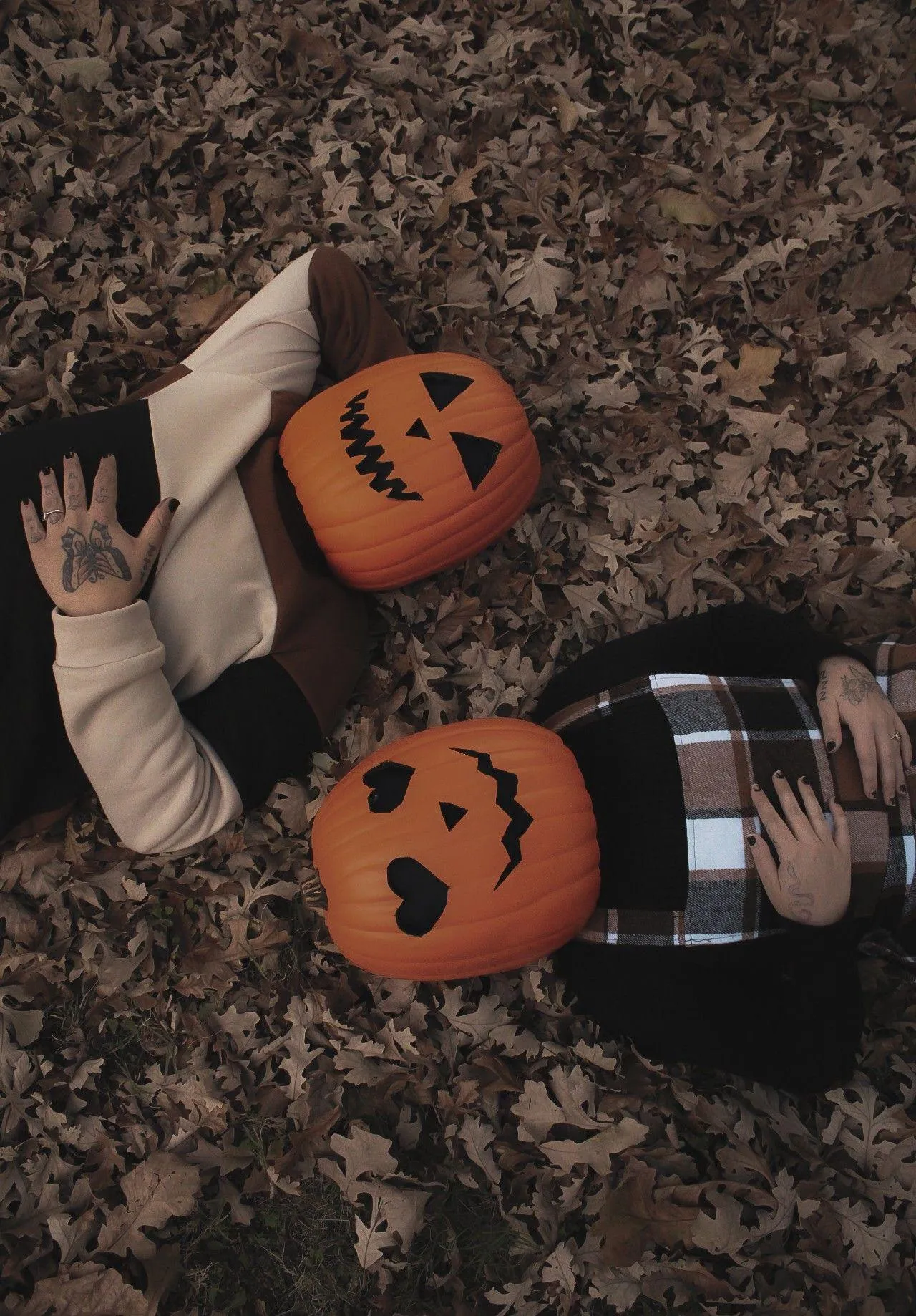 Friends Lying on Leaves Wearing Pumpkin Masks Together