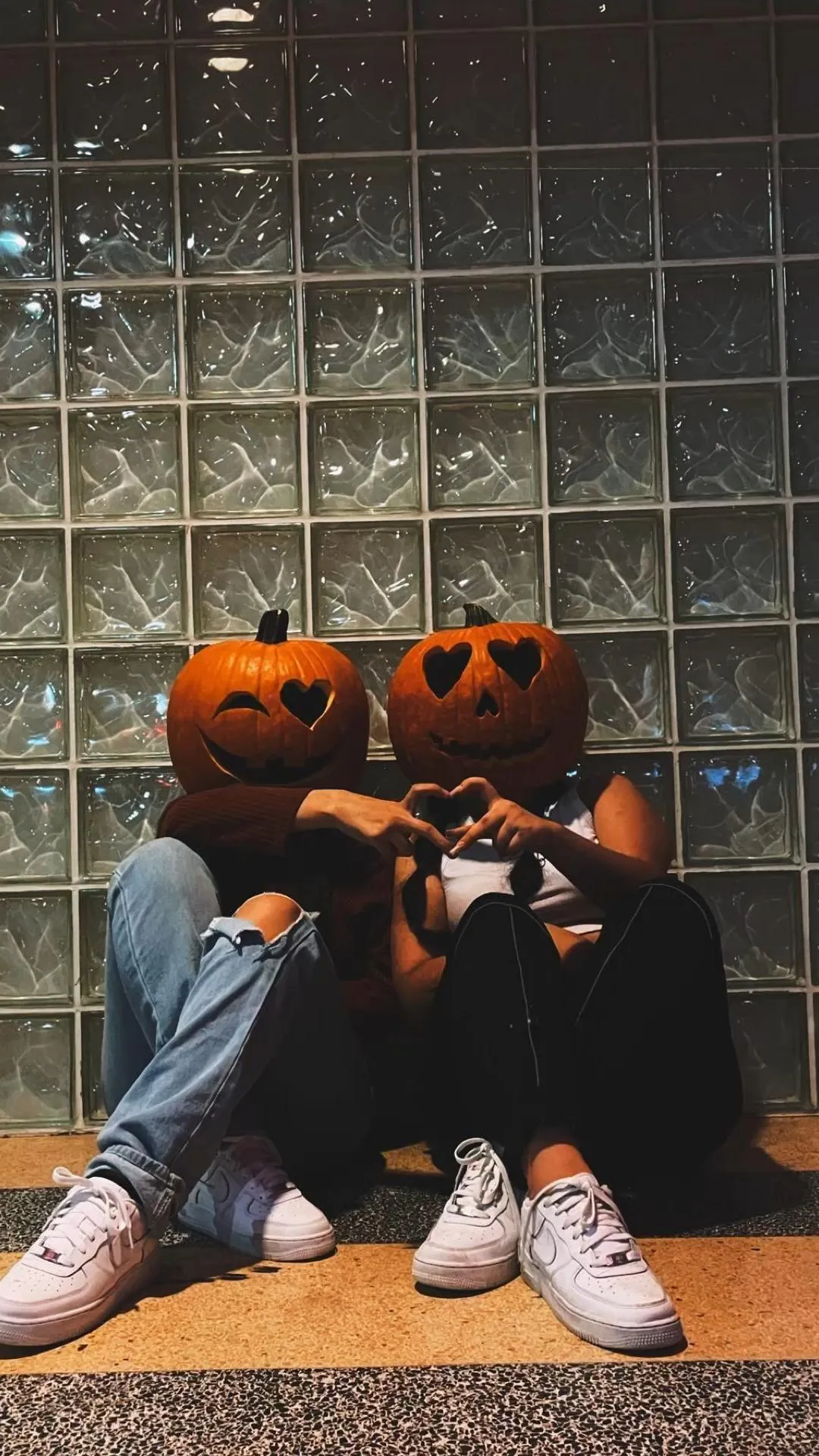 Friends with Pumpkin Heads Sitting on Indoor Bench image