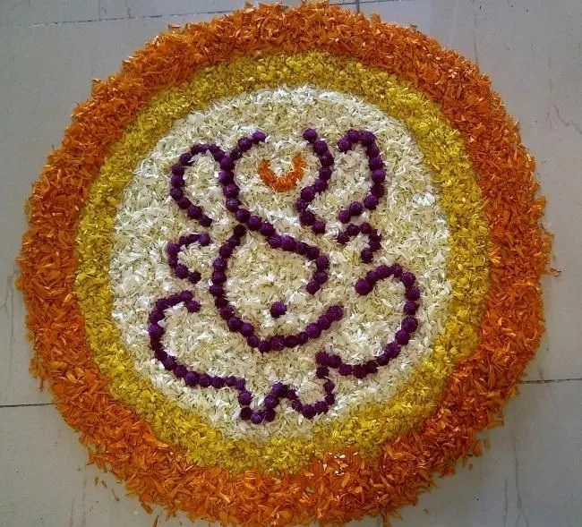 Ganesha pattern kolam with yellow and orange circular layer