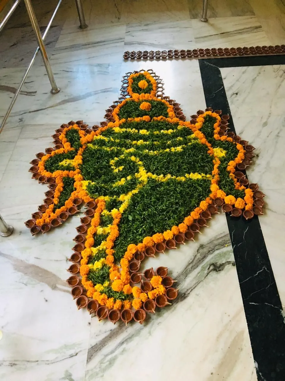 Ganesha Shaped Pookalam Design with marigolds and diyas