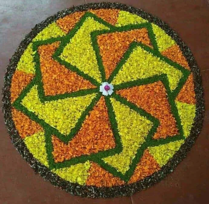 Geometric Onam pookolam design with yellow and orange petals