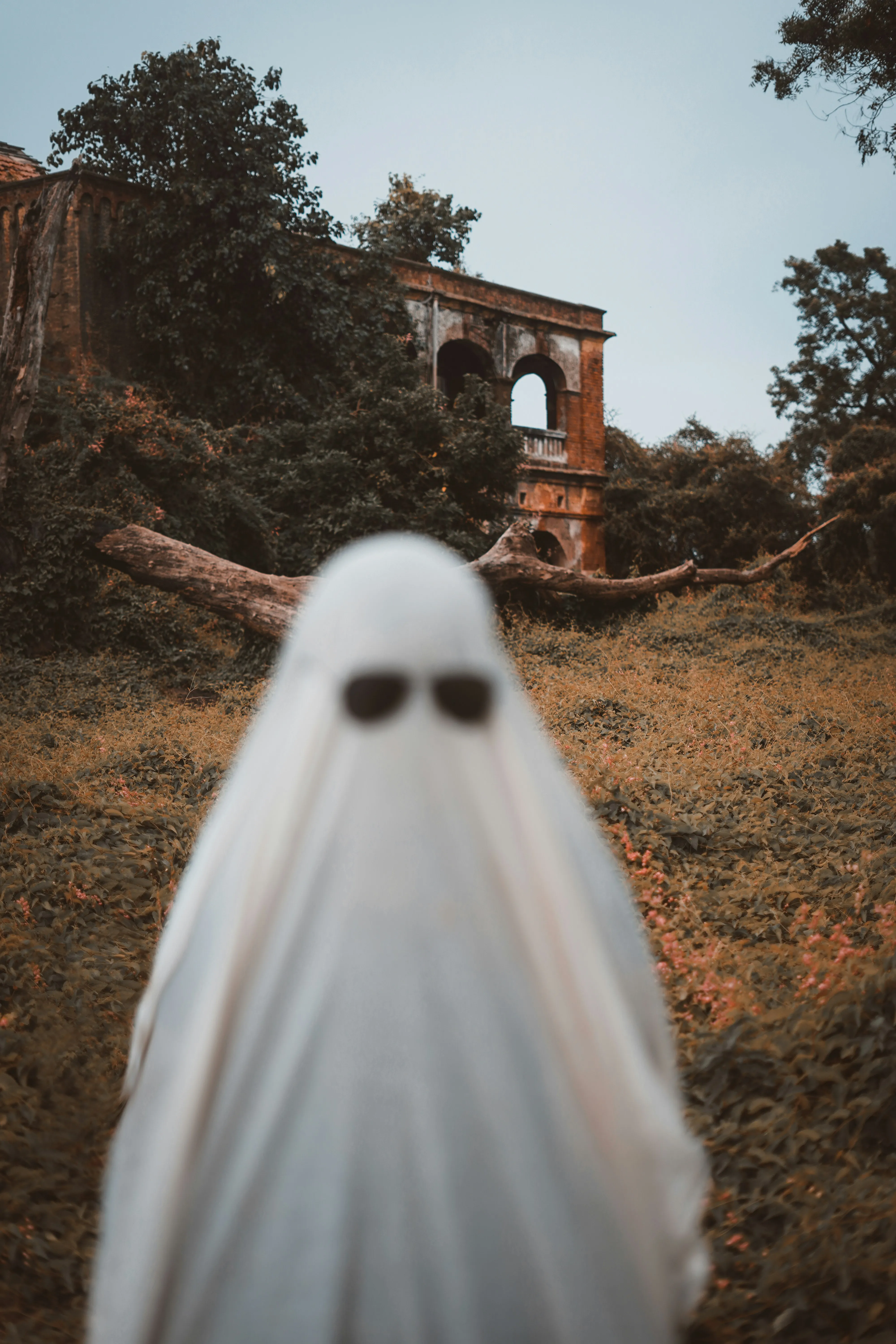 Ghost Costume Figure in Field Near Old Building Wallpaper