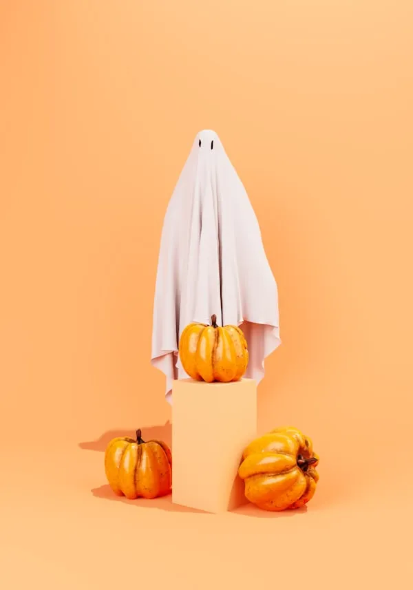 Ghost Costume with Pumpkins on Orange Background Wallpaper