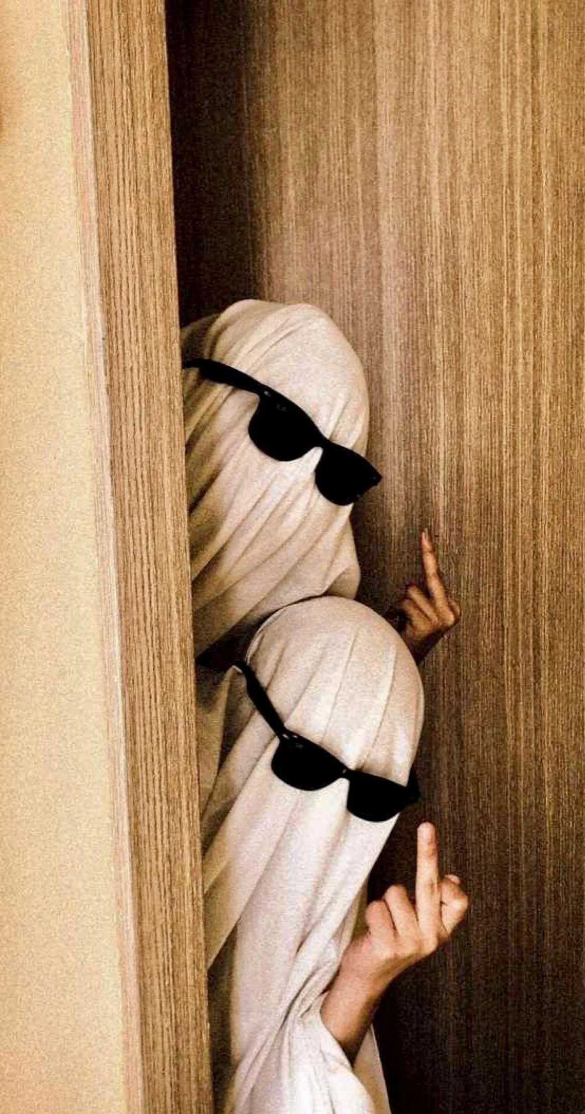 Ghost Costumes Peeking from Curtain in Dimly Lit Room