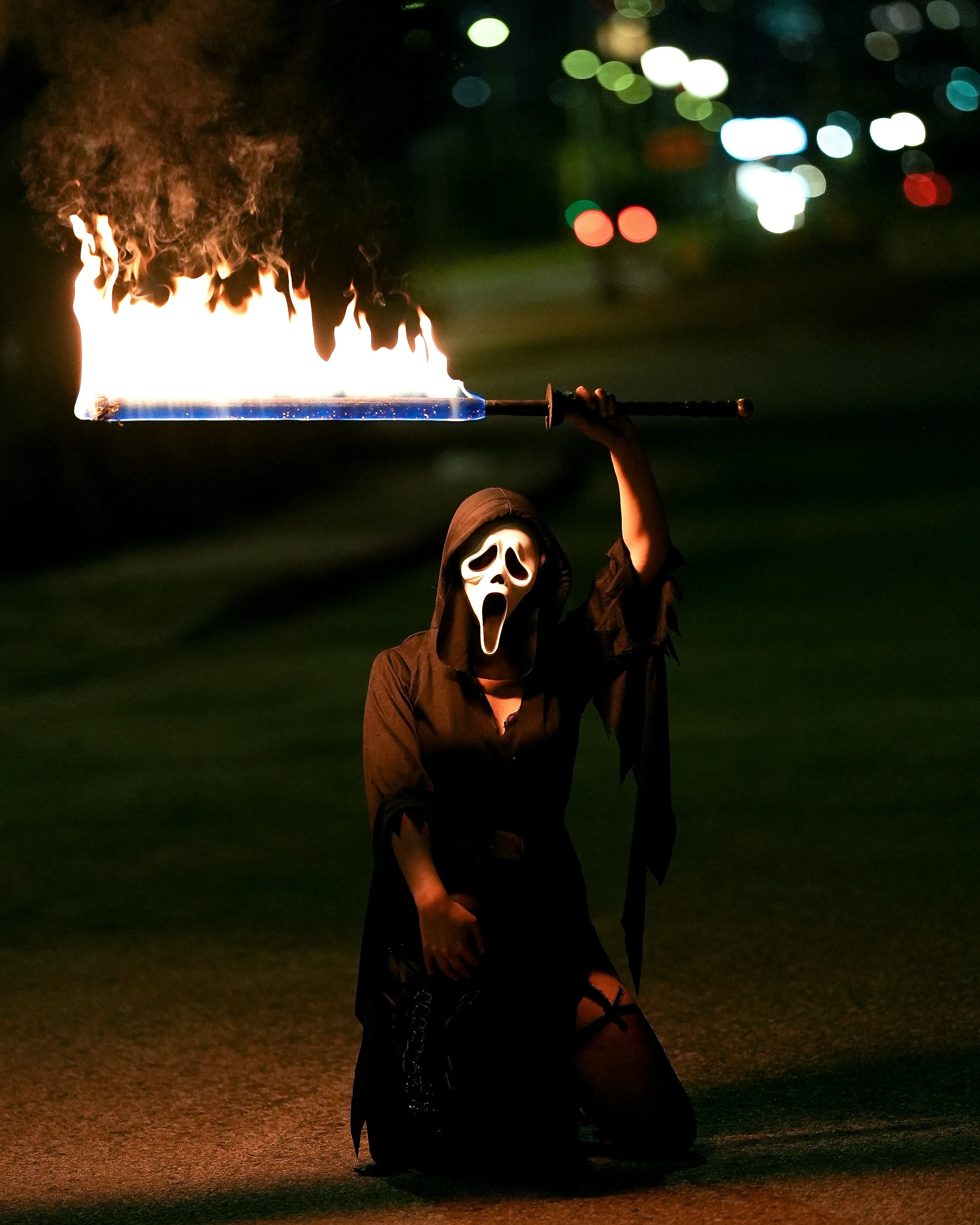 Ghostface Halloween Costume with Flaming Sword at Night