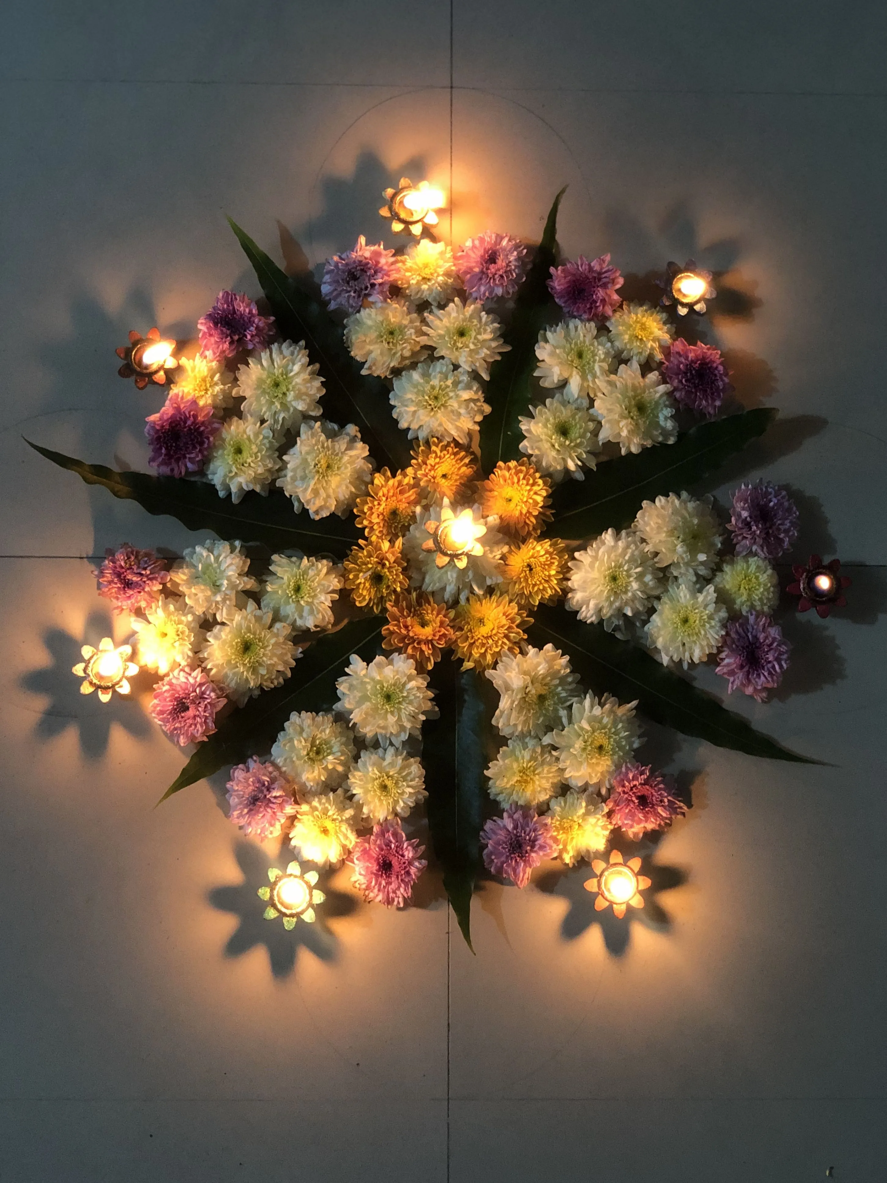 Glowing Onam pookolam with pink white and yellow petals