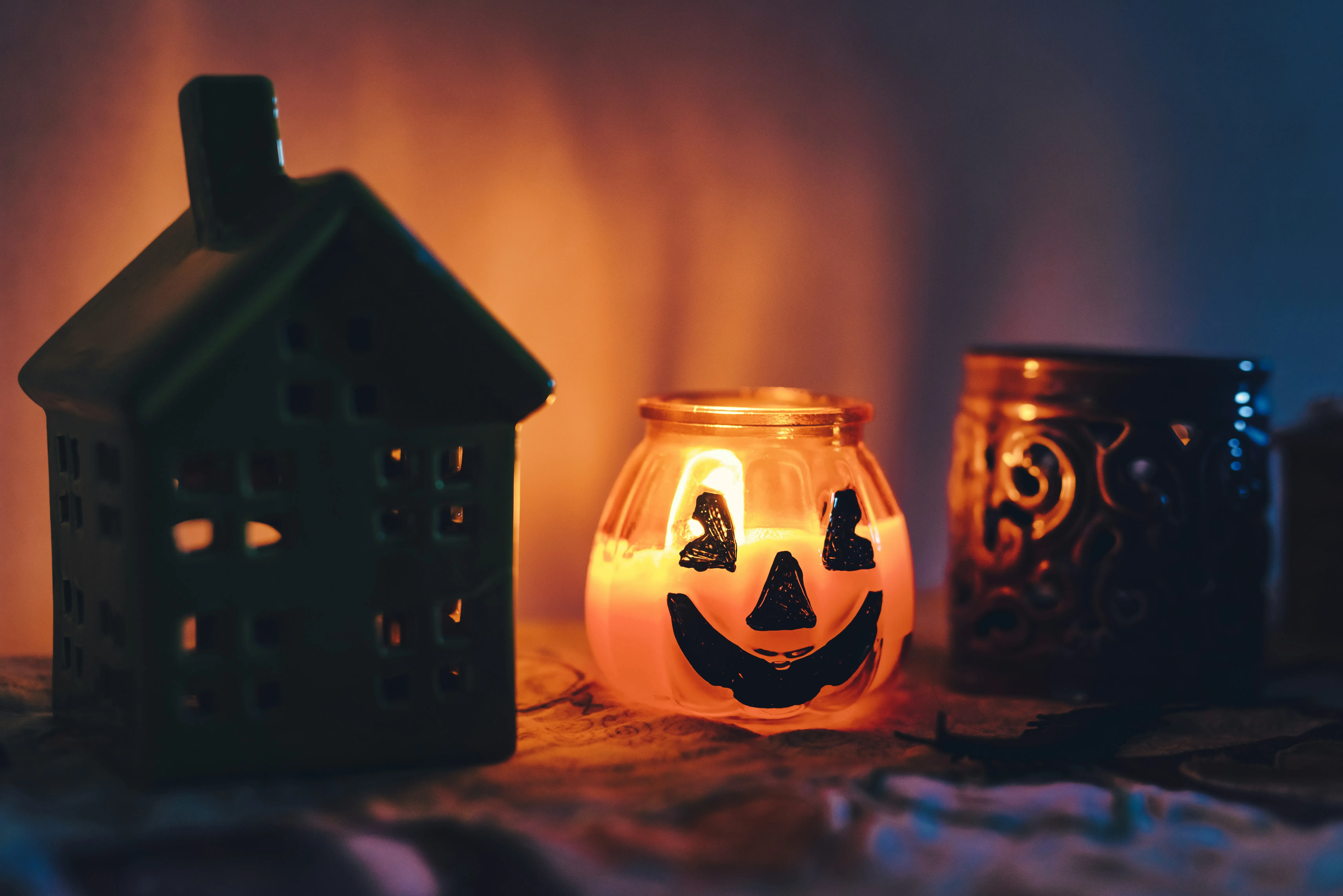 Glowing Pumpkin Lantern Beside Haunted House Decor Image