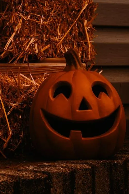 Glowing Scary Jack O Lantern on Hay Bale at Night Image