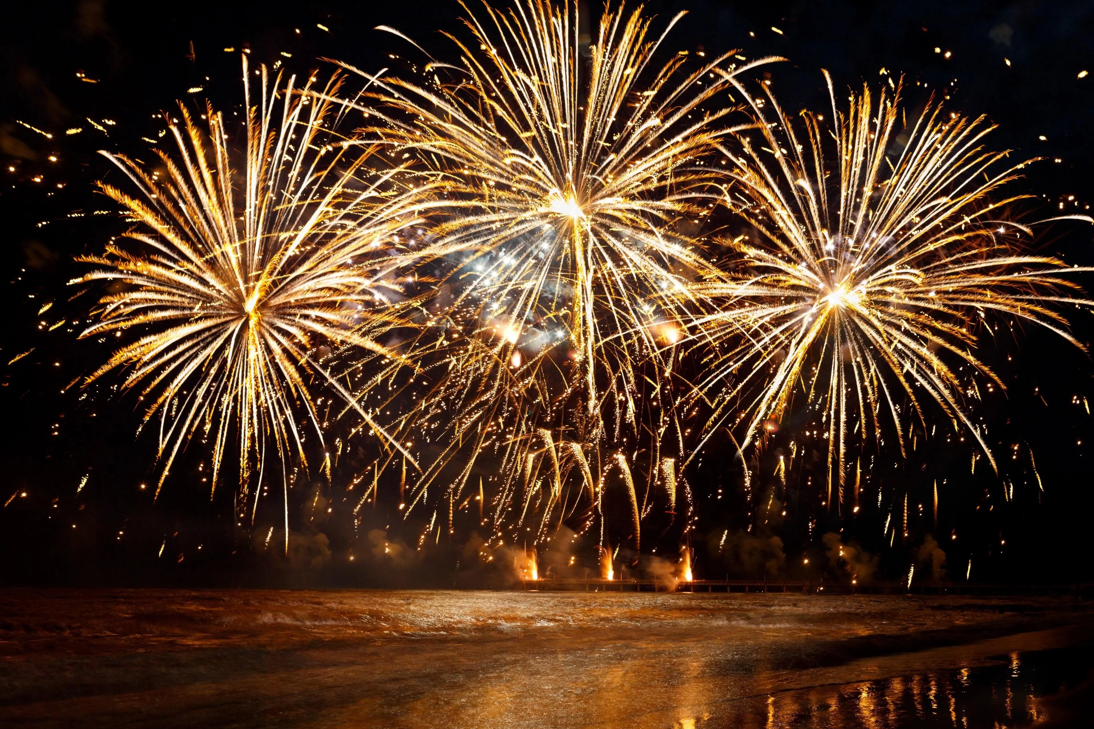 Grand fireworks show lighting up the dark sky over the water