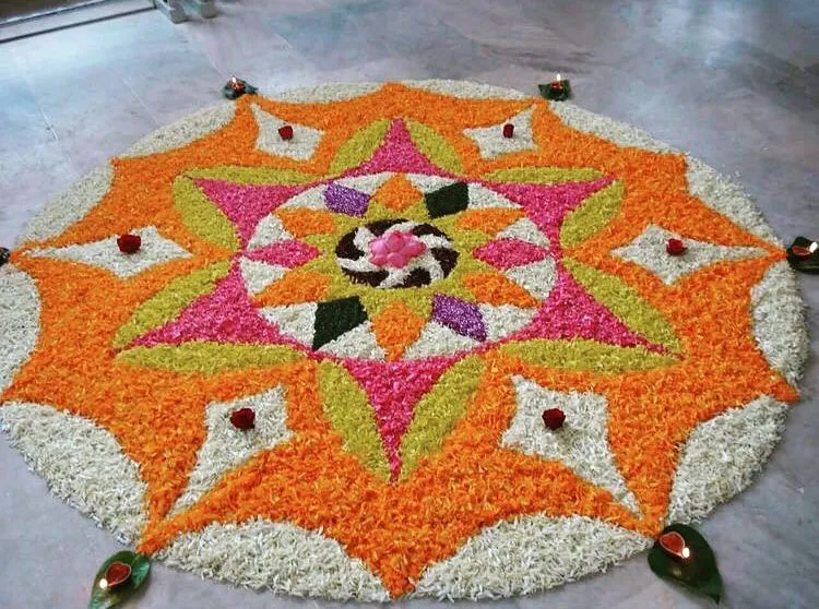 Grand Onam pookolam design with flowers and lamps wallpaper