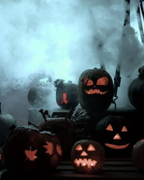 Group Of Jack O Lanterns Surrounded By Fog in Dark Setting