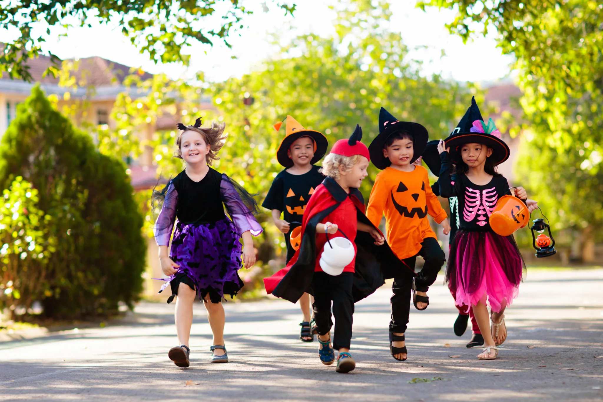 Group of Kids in Colorful Halloween Costumes Running Outdoors
