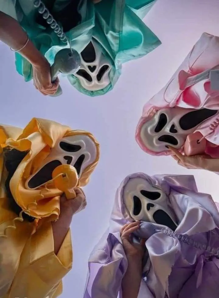 Group of people in colorful ghost masks looking down HD