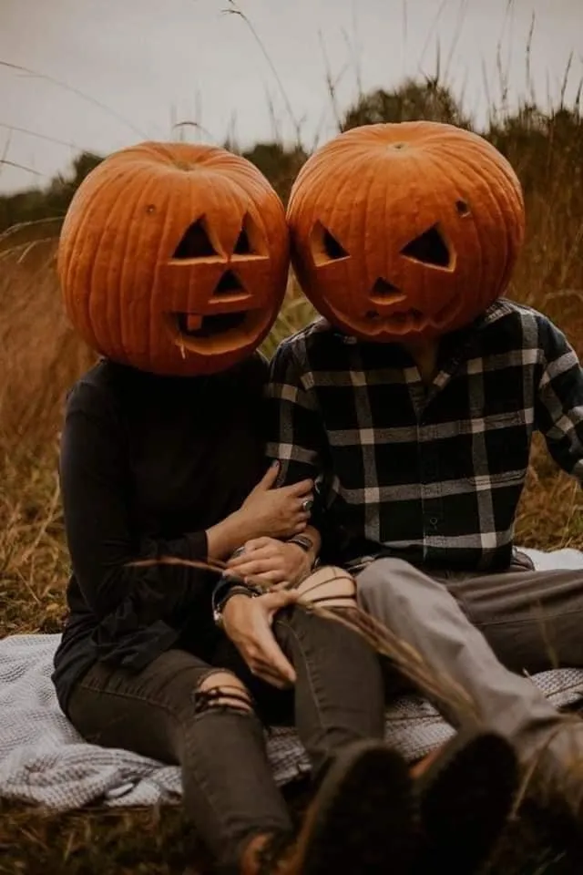 Halloween festival couple with pumpkin heads sitting together