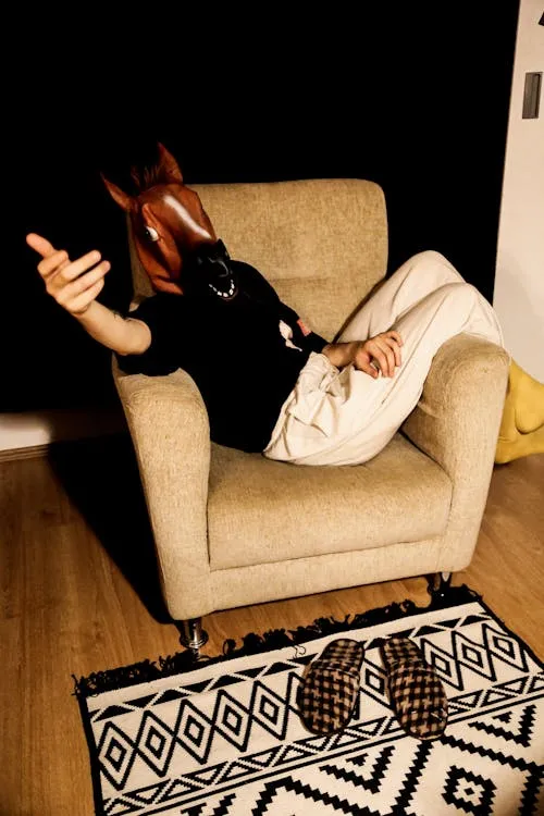 Halloween Festival Person in Horse Mask Sitting on Chair image