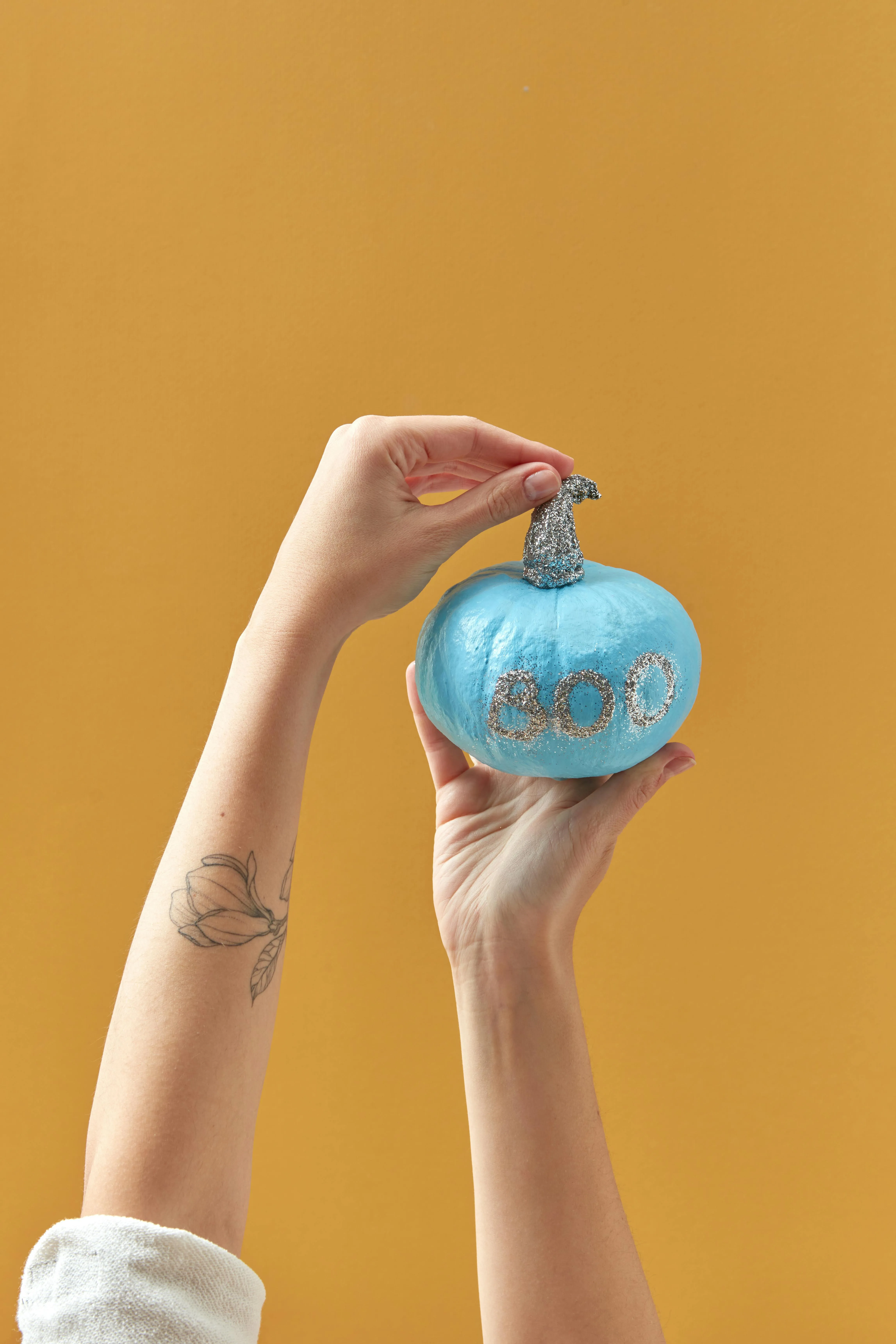 Hand Holding Blue Halloween Pumpkin Decoration Image