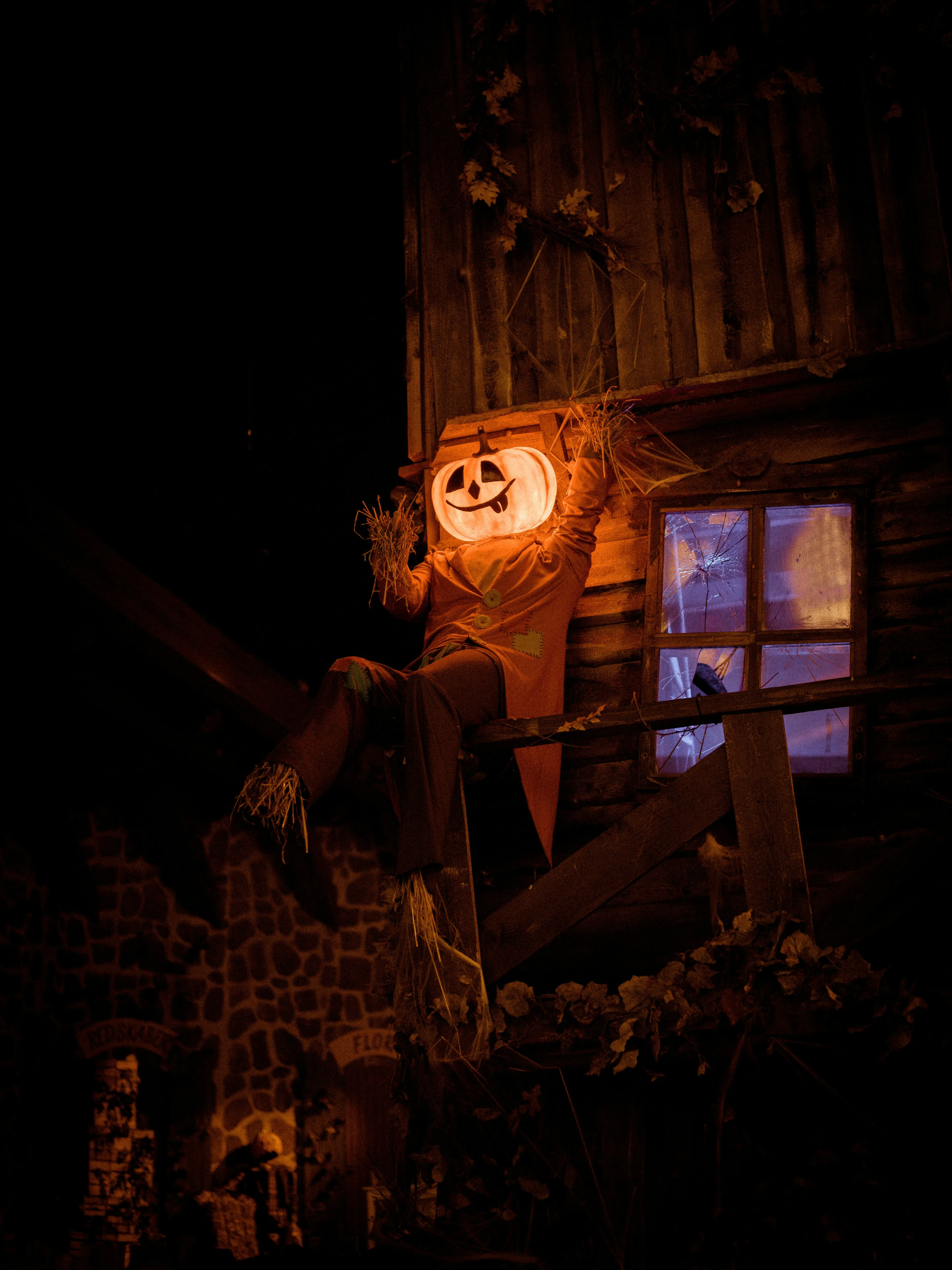 Haunted House Window with Glowing Pumpkin Face Wallpaper