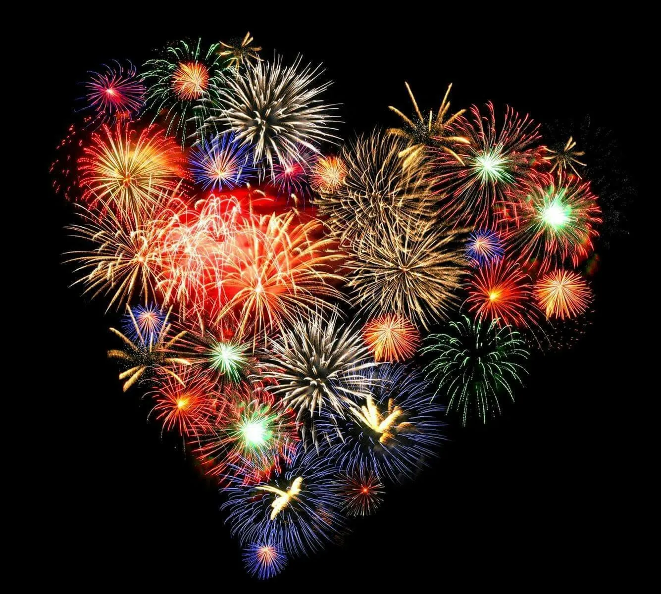 Heart shaped pattern formed by fireworks lighting up night sky