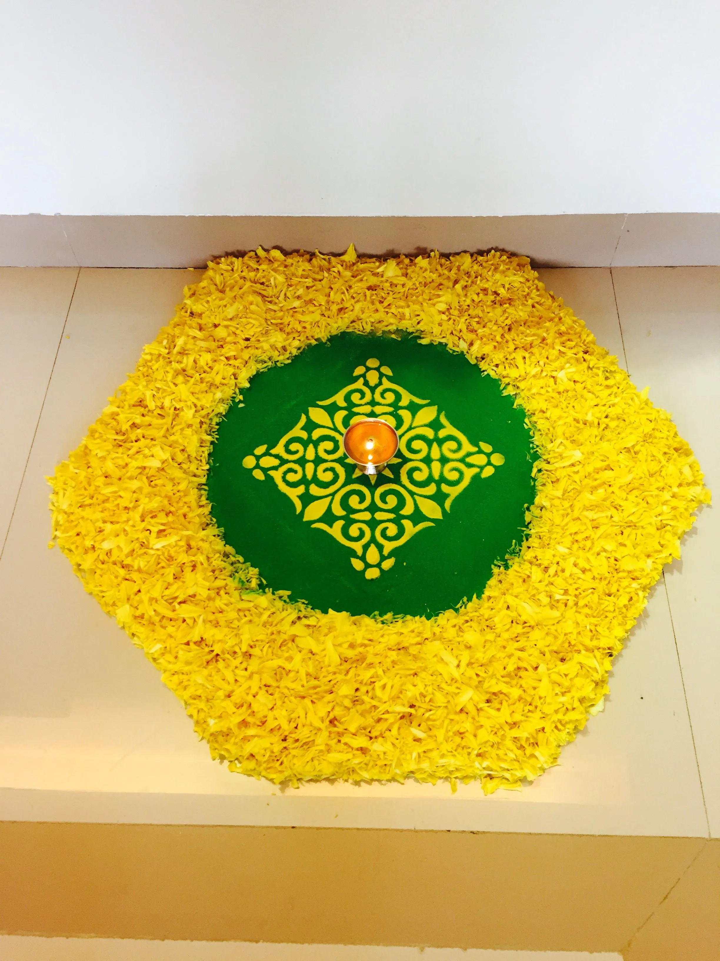 Hexagon shaped pookolam with traditional diya at the center