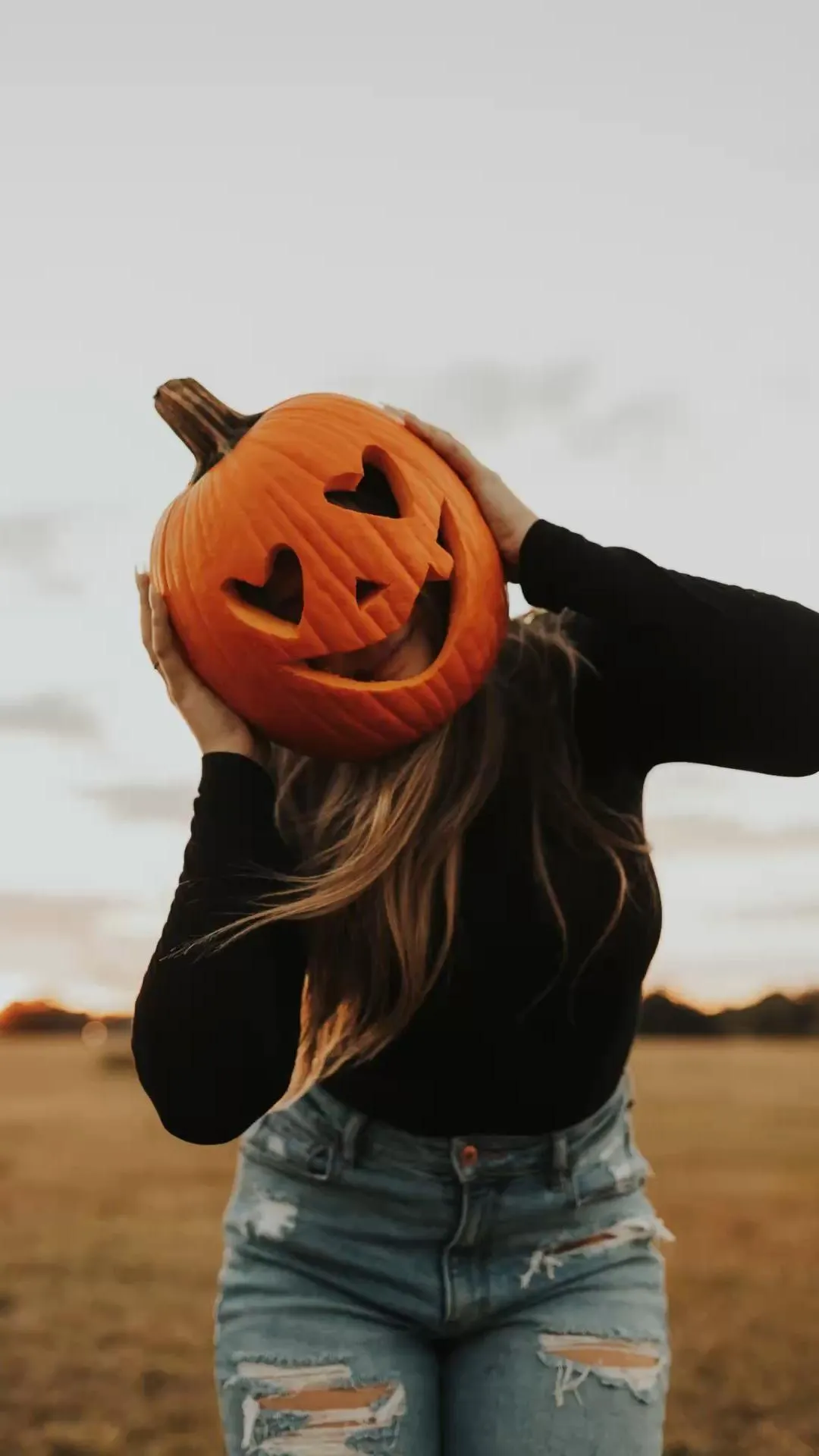Individual Wearing Pumpkin Head Mask in Casual Outfit