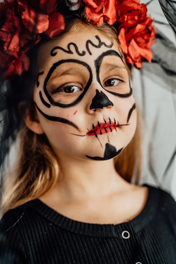 Kid with skeleton face paint and red flower crown image