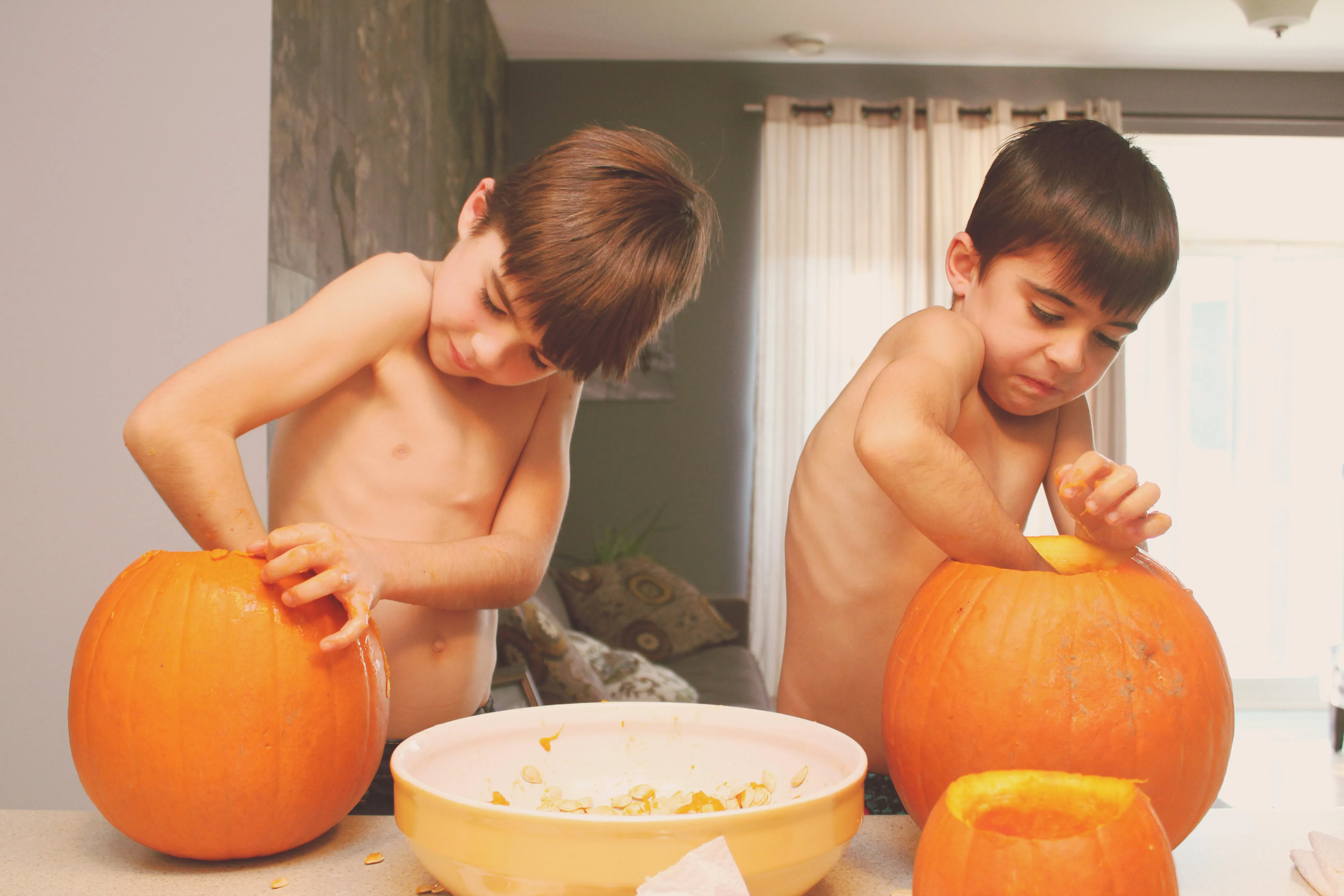 Kids Carving Pumpkins Indoors For Halloween Fun Wallpaper