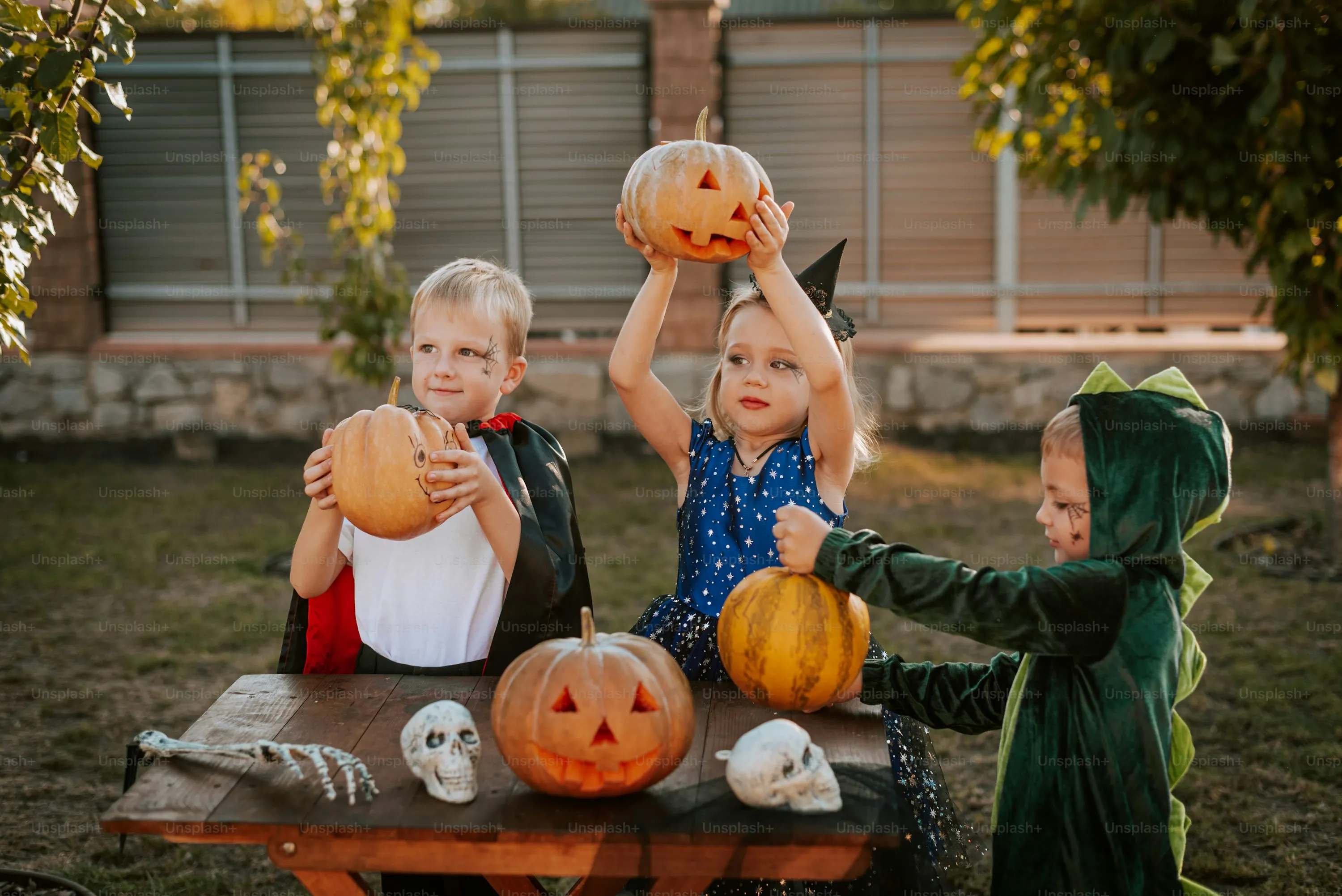 Kids Holding Jack O Lantern Pumpkins in Backyard Wallpaper