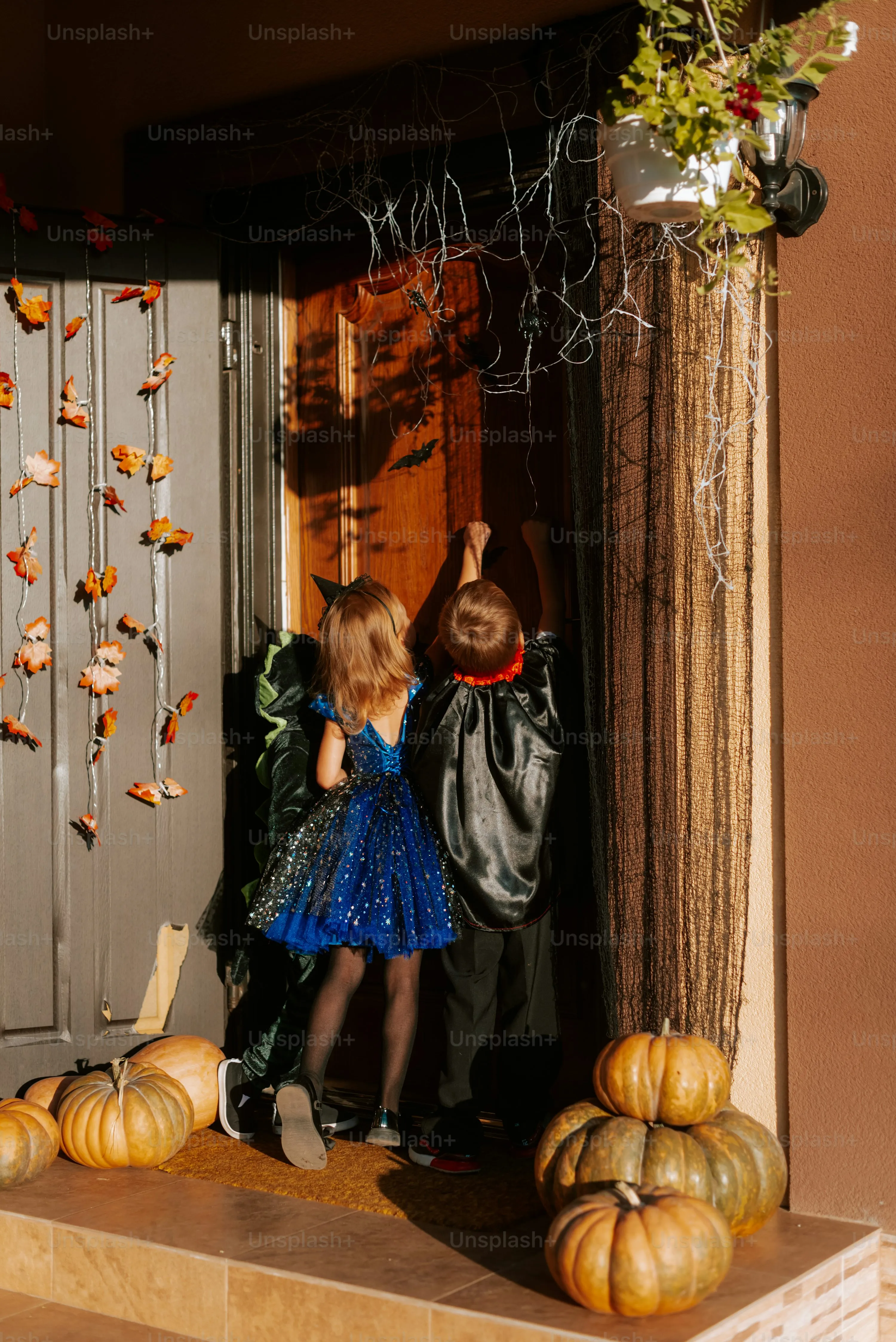 Kids Trick or Treating in Halloween Costumes at Doorstep