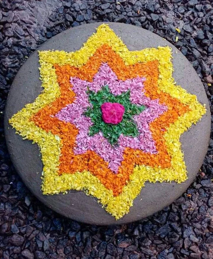 Layered star mini Onam pookolam on a gray stone Wallpaper