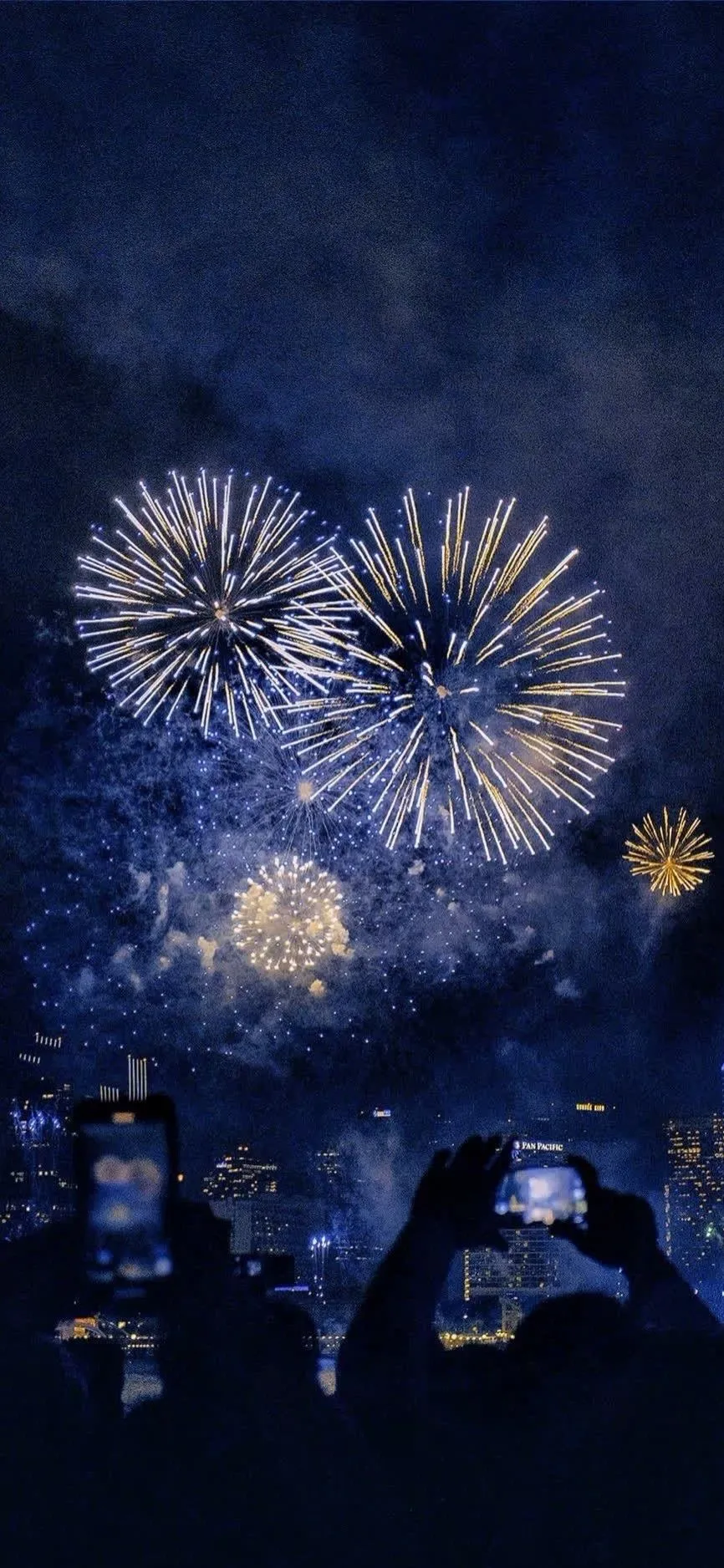 Magnificent fireworks over houses lighting up the night sky