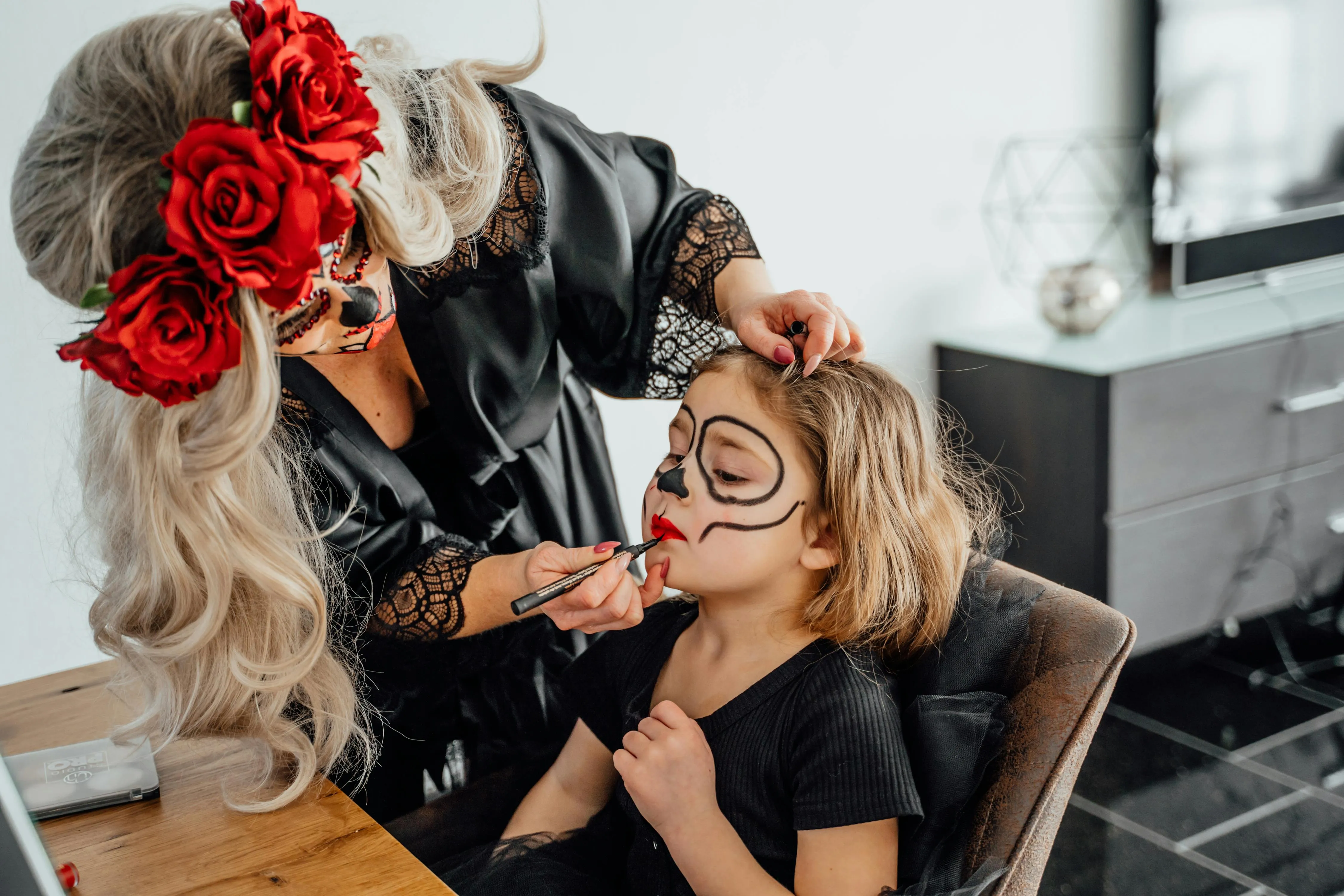 Makeup Artist Applying Sugar Skull Face Paint to kid image