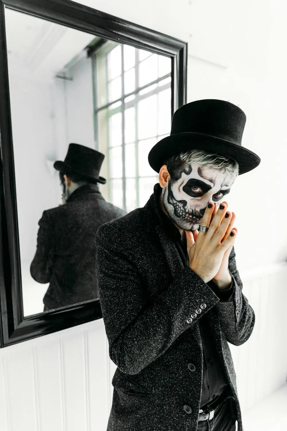 Man in Top Hat and Skull Mask standing near the Mirror