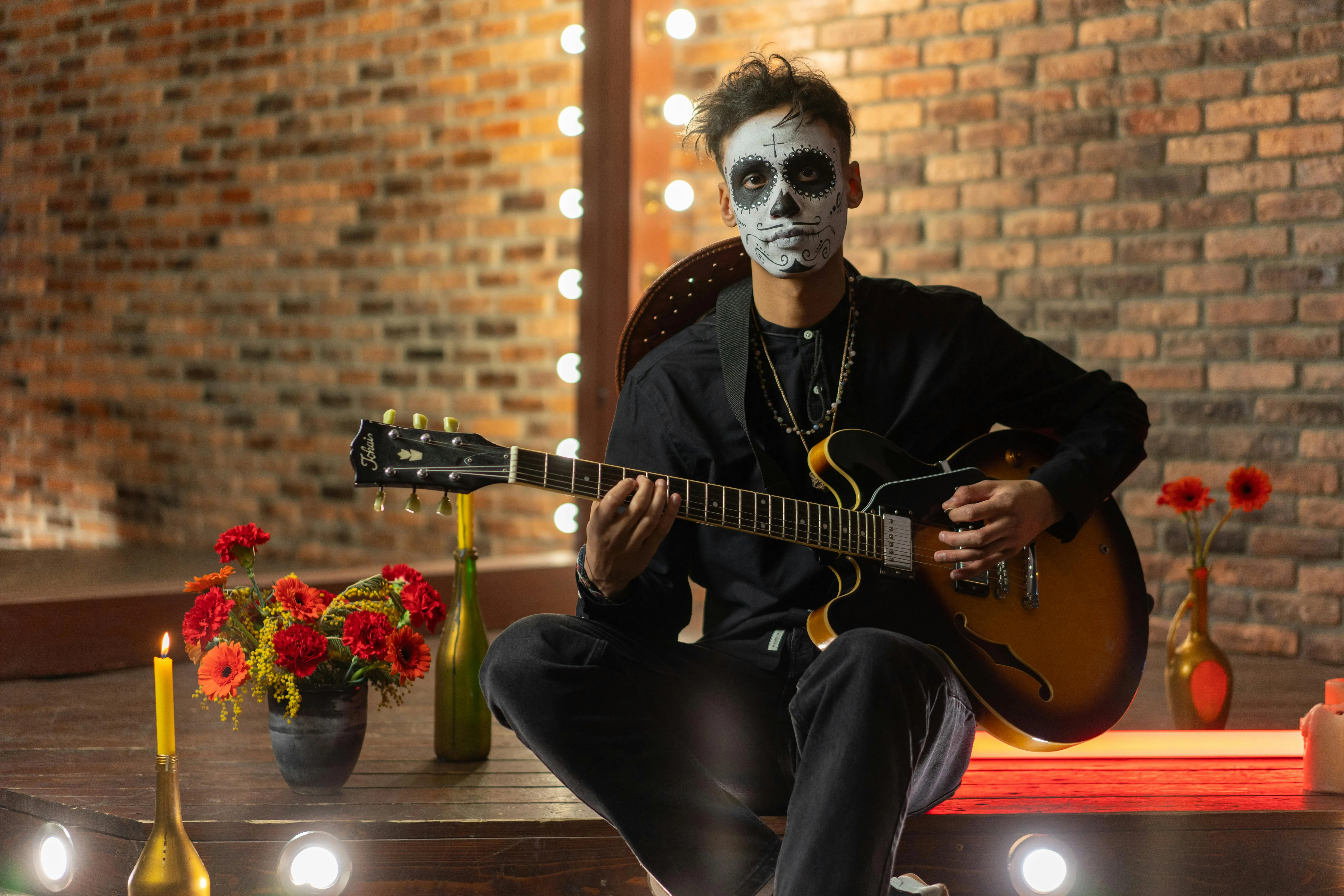 Man Playing Guitar in Halloween Costume Indoors Wallpaper