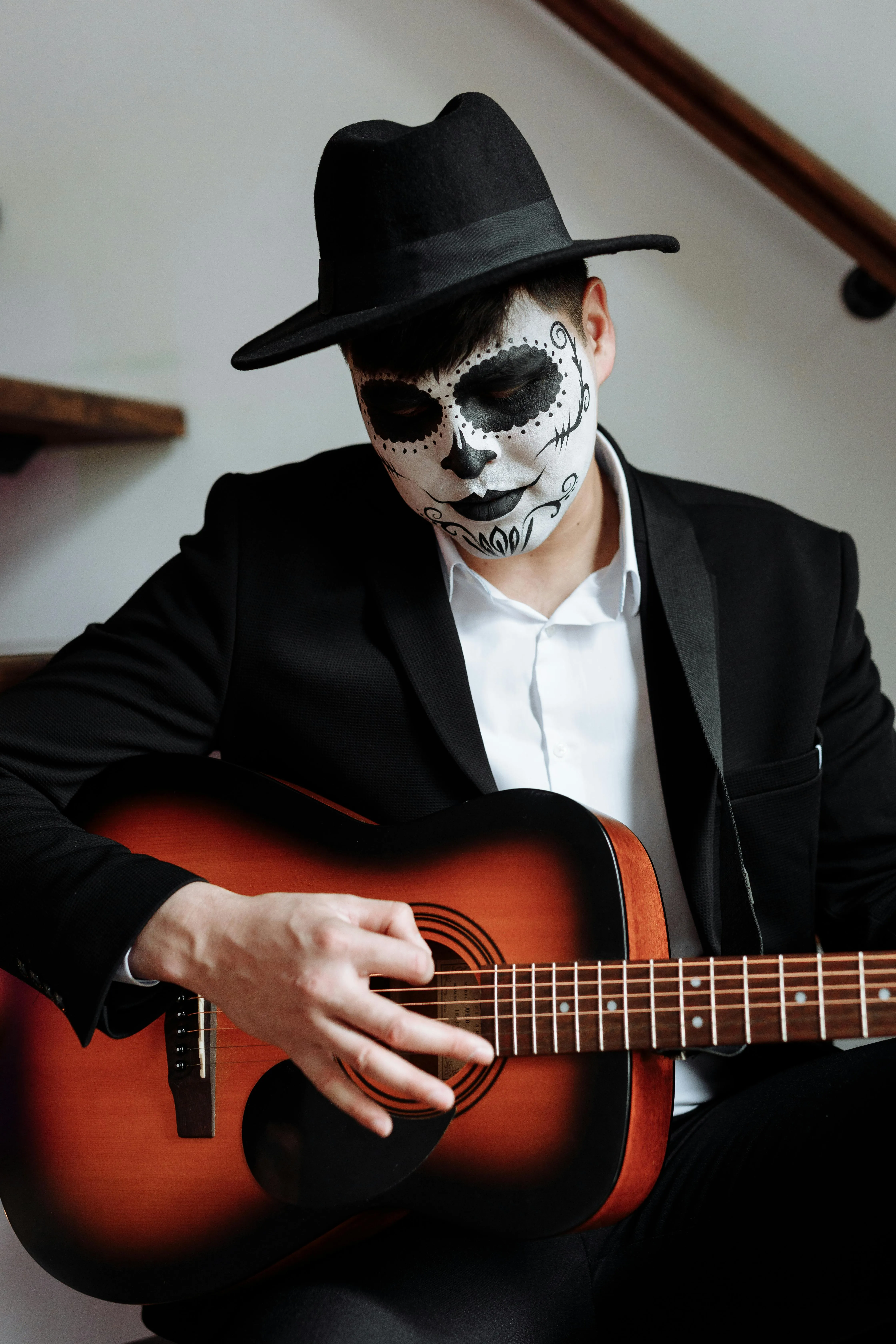 Man Playing Guitar Wearing Skeleton Makeup and Hat