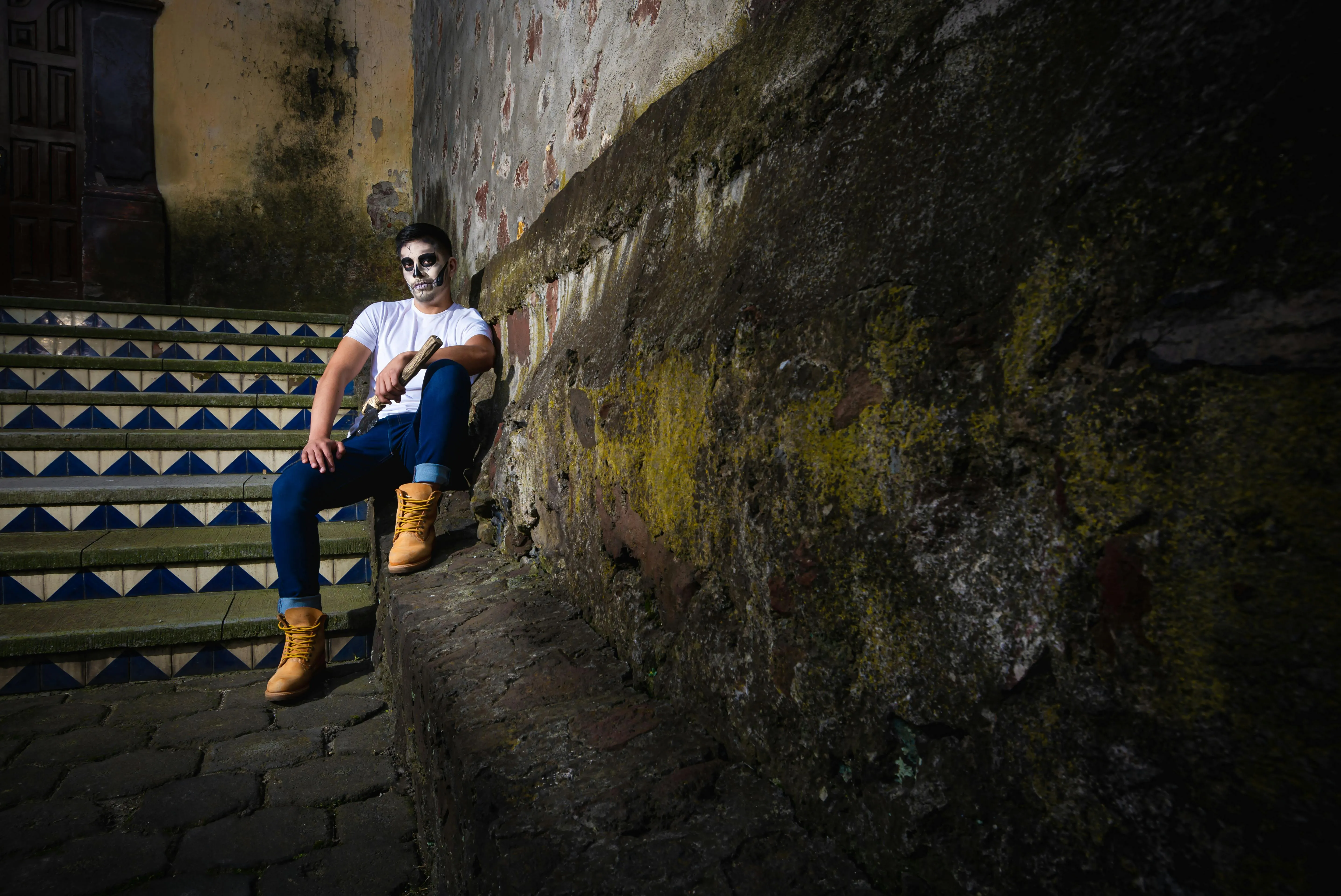 Man Sitting on Halloween Lit Steps in Urban Alley Wallpaper