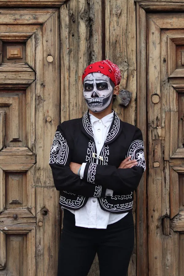Man with Skull Makeup and Red Bandana Posing Near Wooden Door
