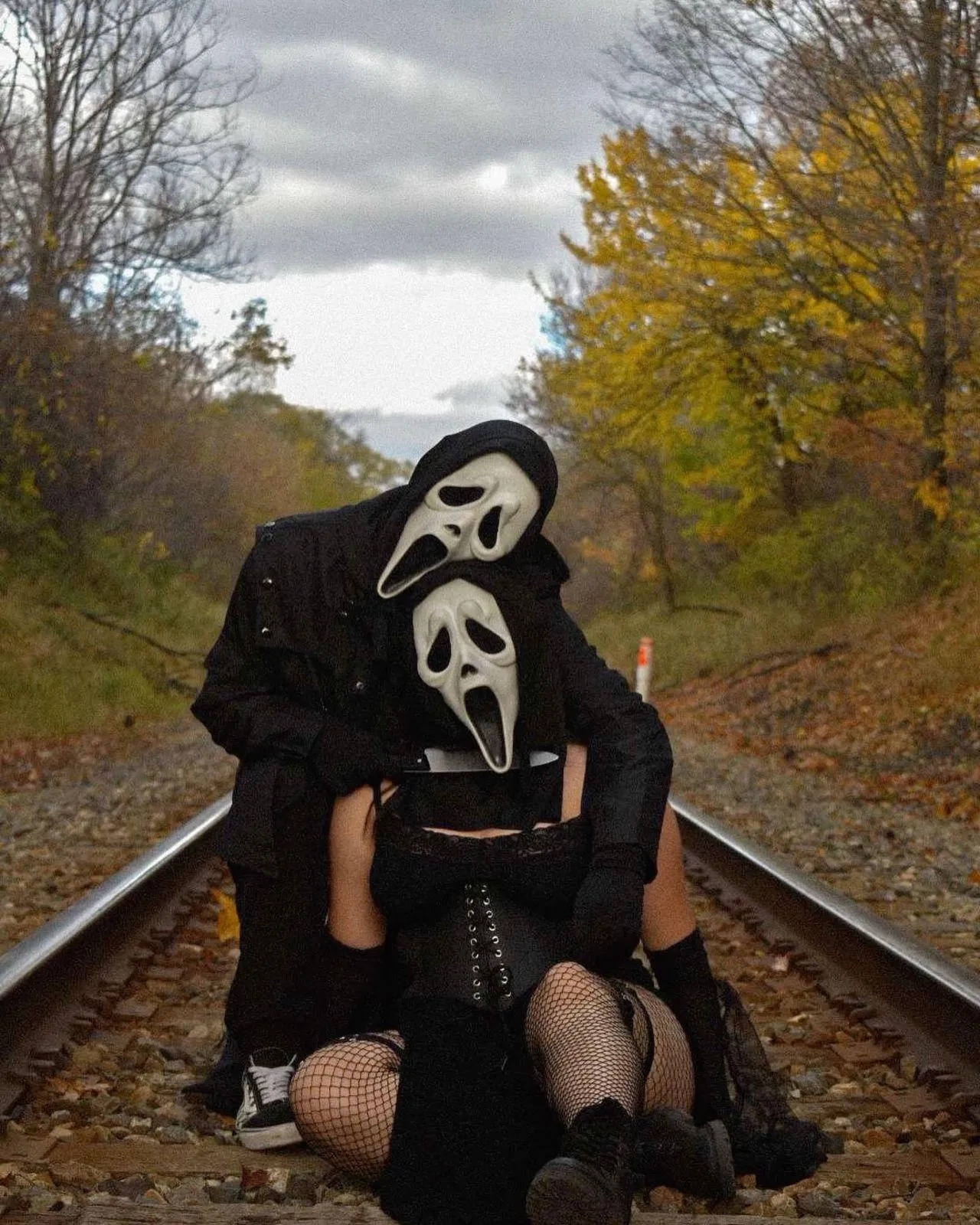 Masked Figure on Railroad Tracks with forest Background