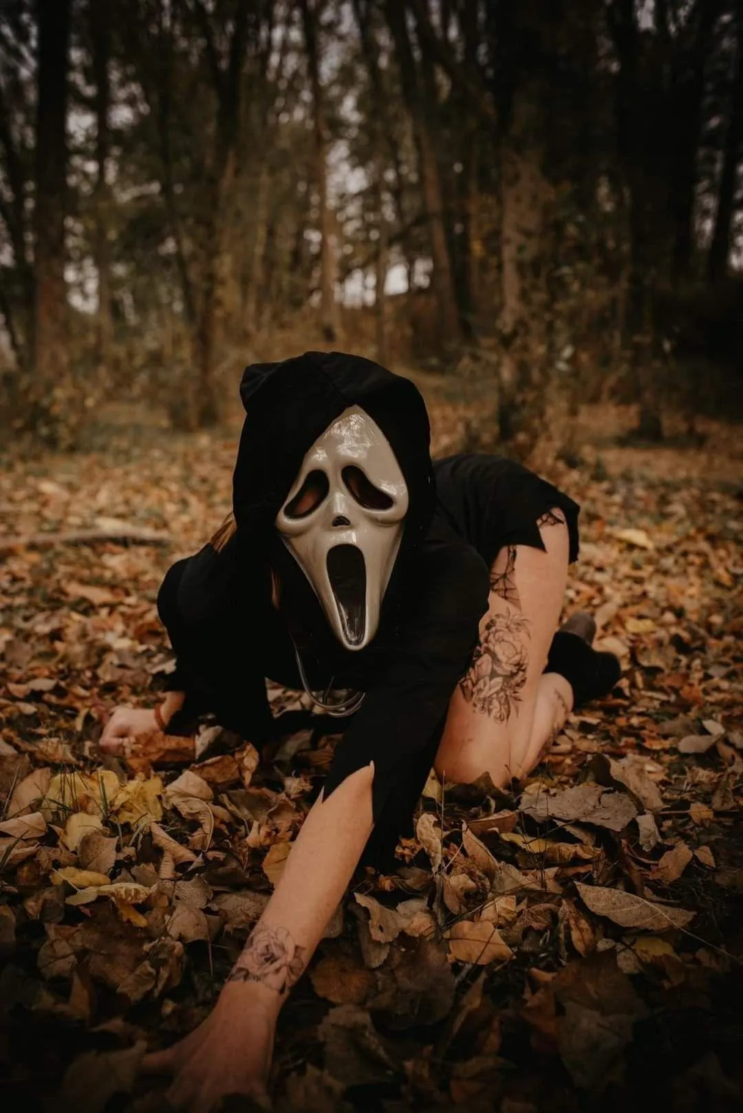 Masked Halloween Character Crawling in Leaves Wallpaper